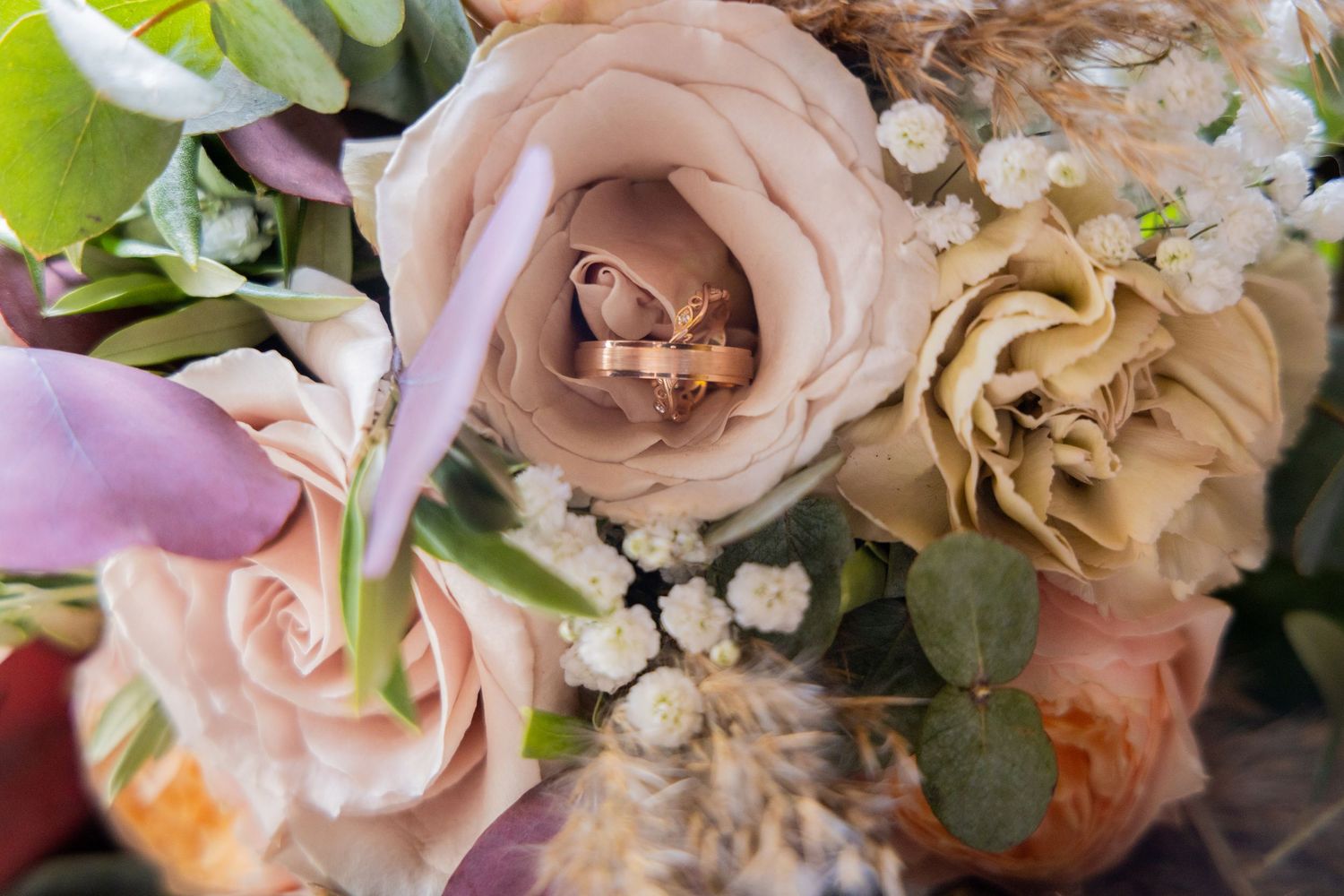 Close up macro shot of pale pink roses and mixed flowers in a dreamy romantic wedding bouquet arrangement.