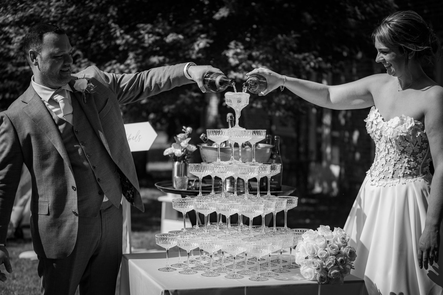 Wedding party toasting with champagne glasses at outdoor celebration.