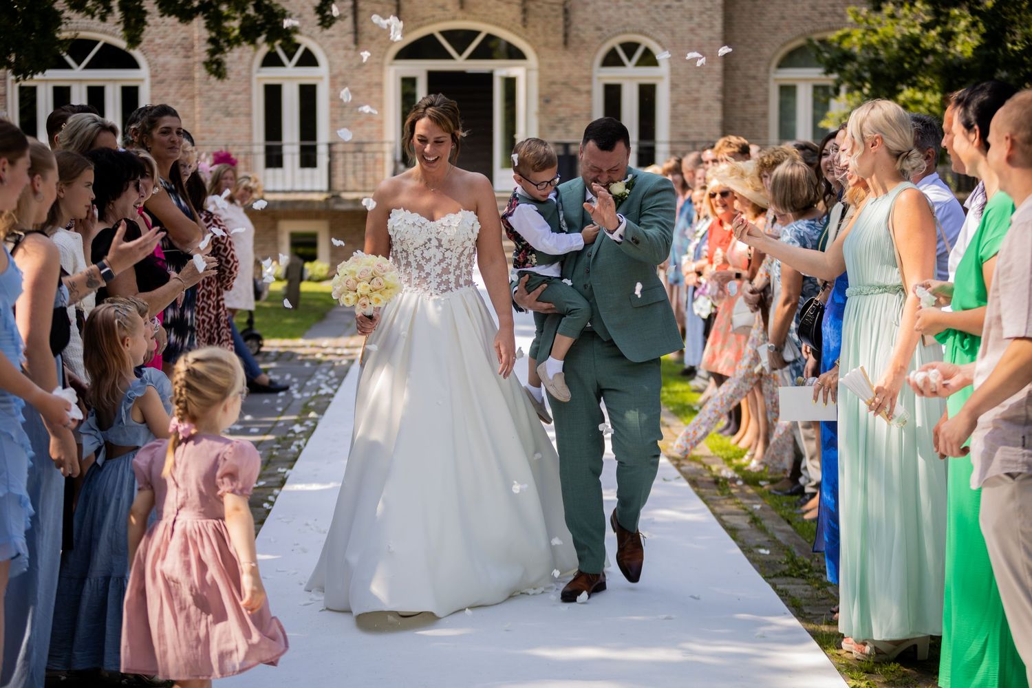 Wedding celebration on an elegant stone building grounds with guests in colorful attire.