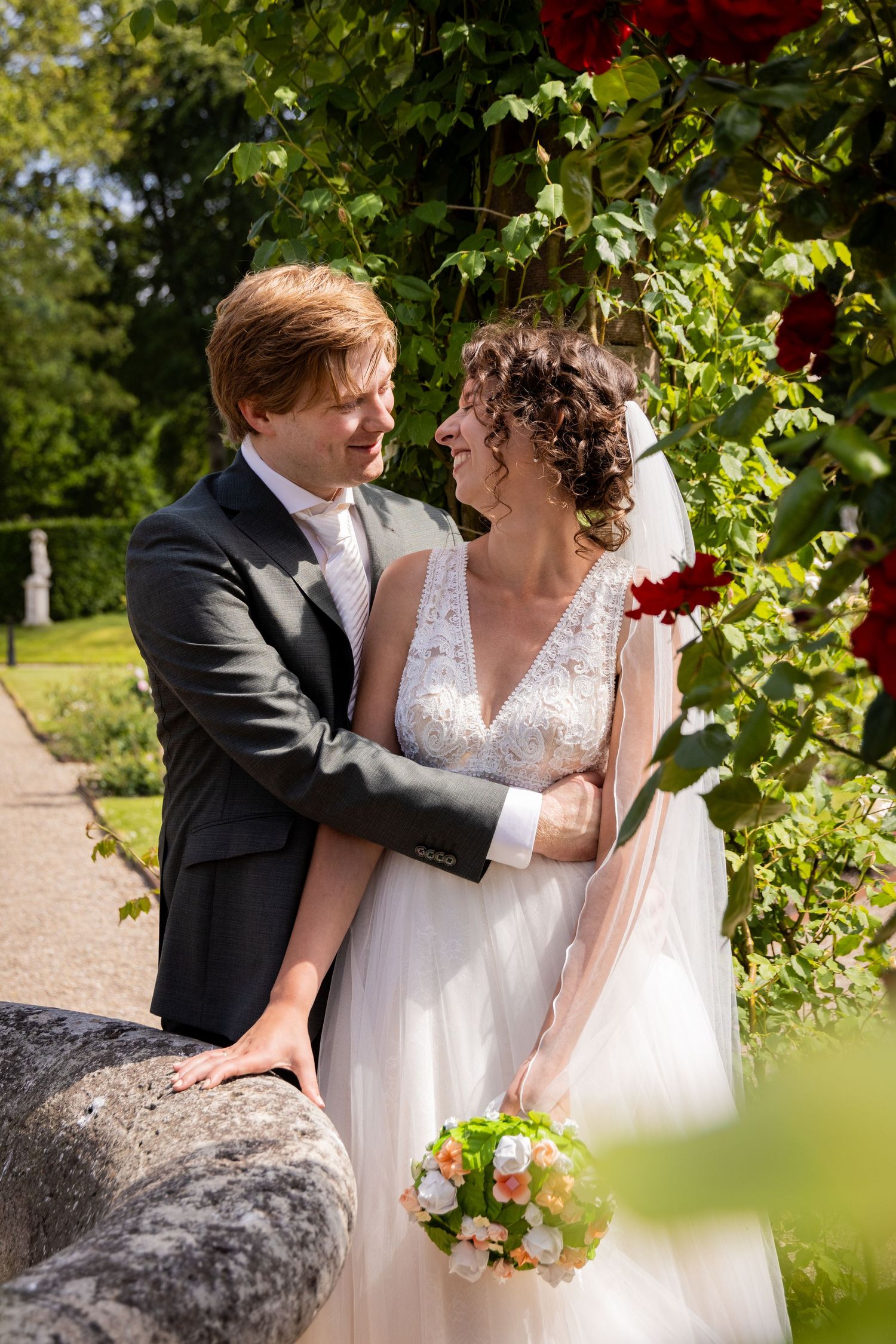 Romantic garden wedding portraits showcase tender moments between newlyweds among lush greenery.