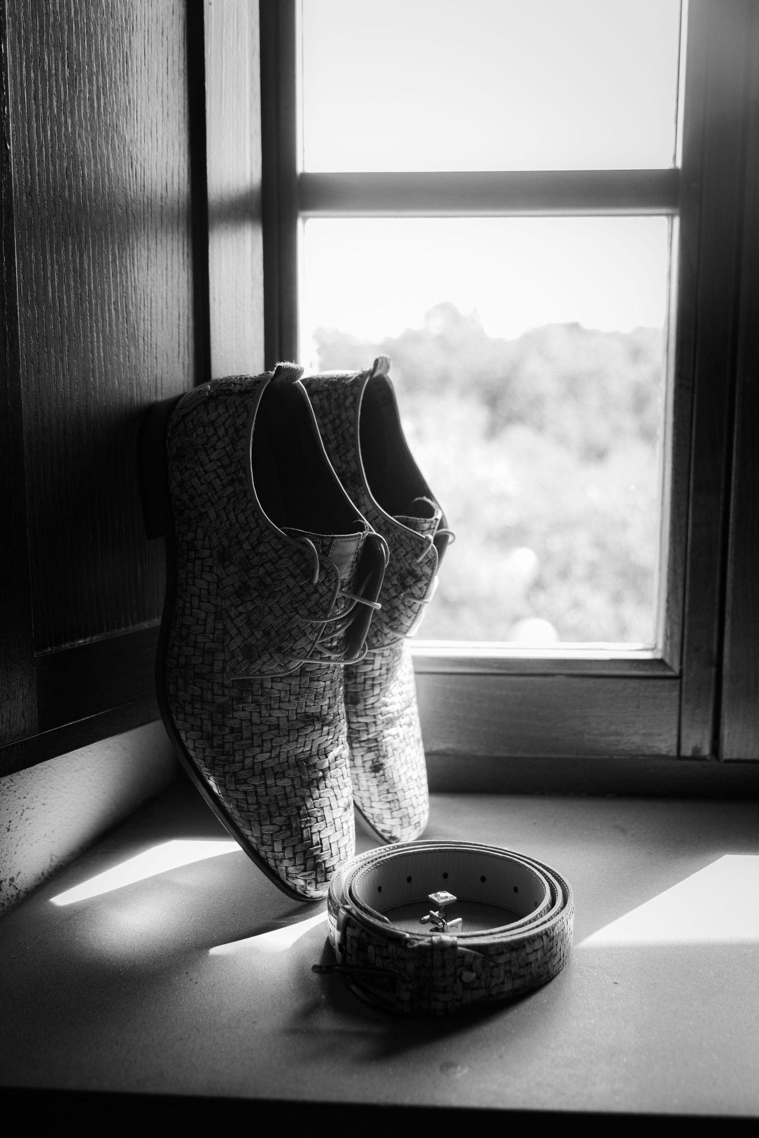 A monochromatic series of five photos showing a woven basket sitting on a windowsill at different angles in dramatic light.