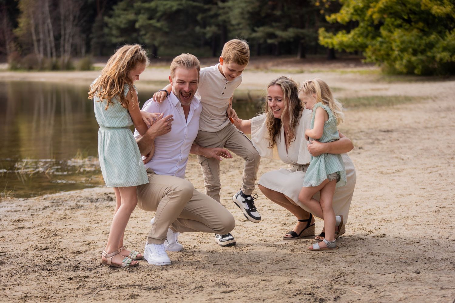 Joyful family group playing and laughing together on a beach.