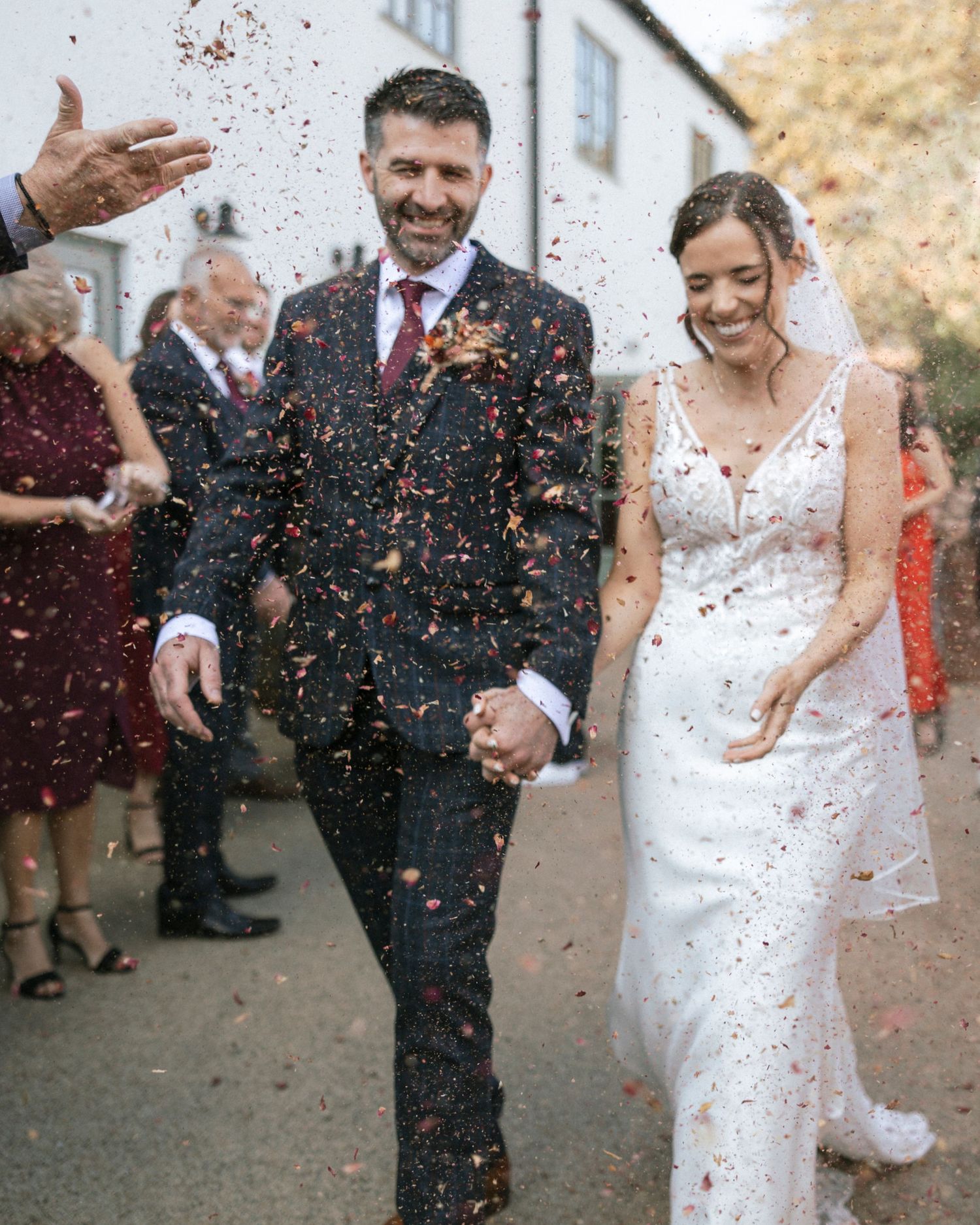 Celebratory moment showing confetti being thrown at joyous couple after wedding ceremony.