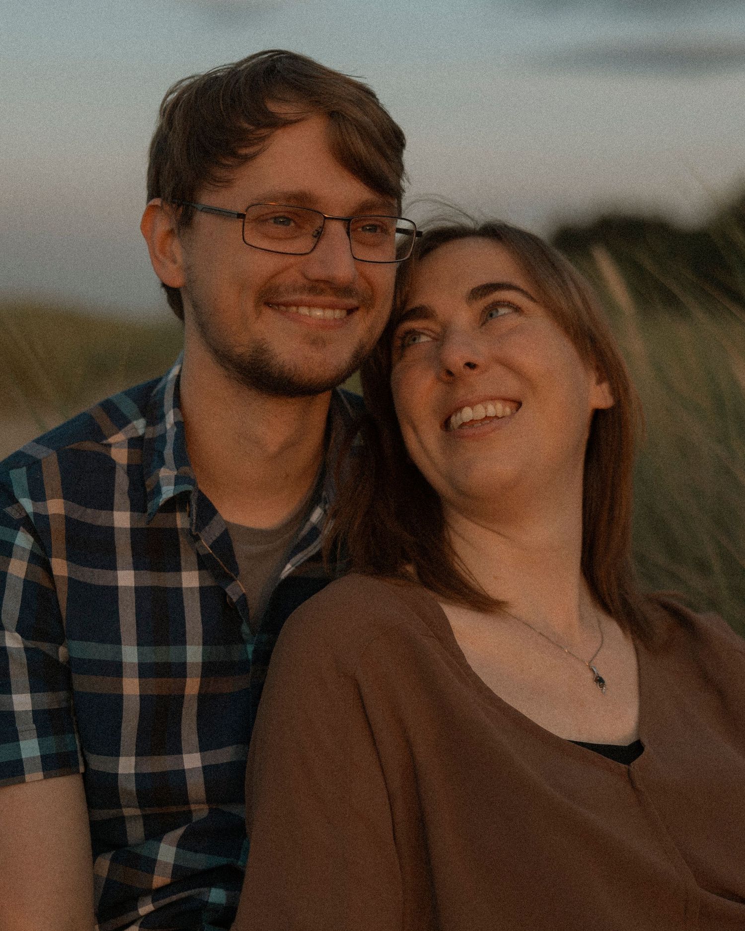 Romantic sunset portrait of couple smiling together outdoors.