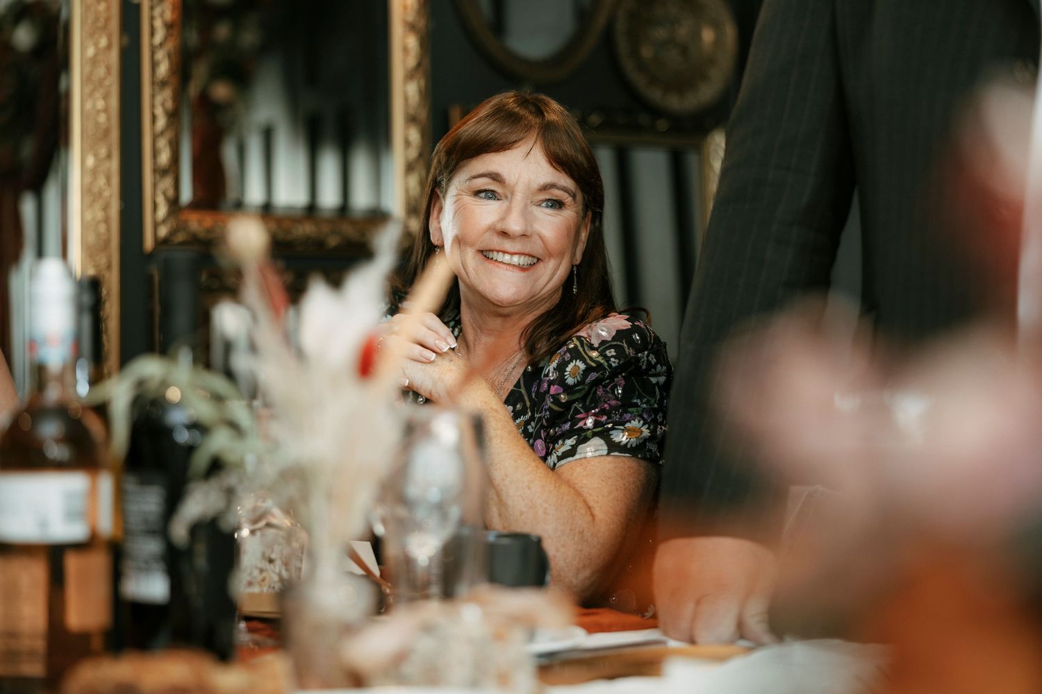 Candid moment captured during a dinner party with warm lighting and vintage decor.
