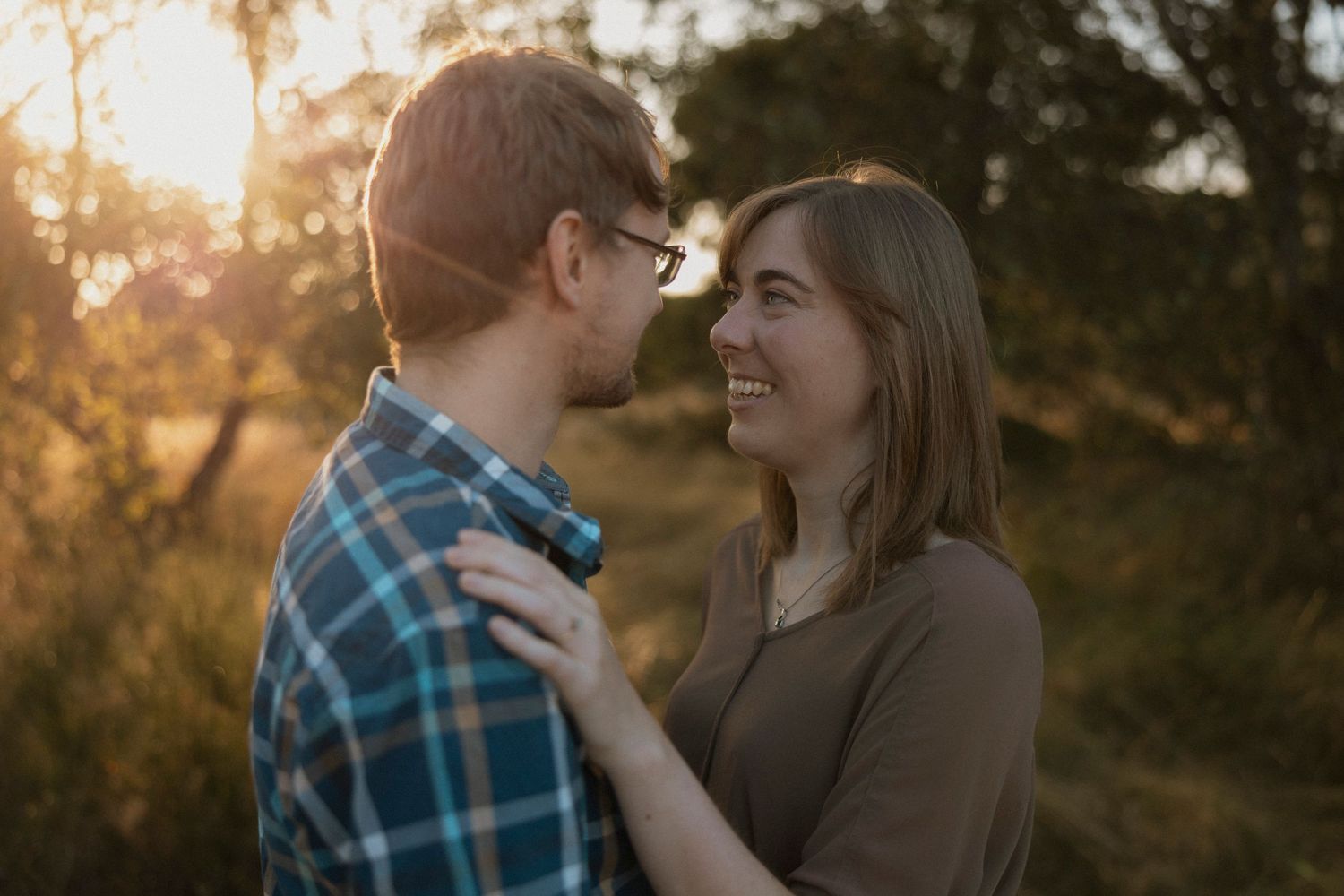 Romantic couple sharing a tender moment in golden sunset light.