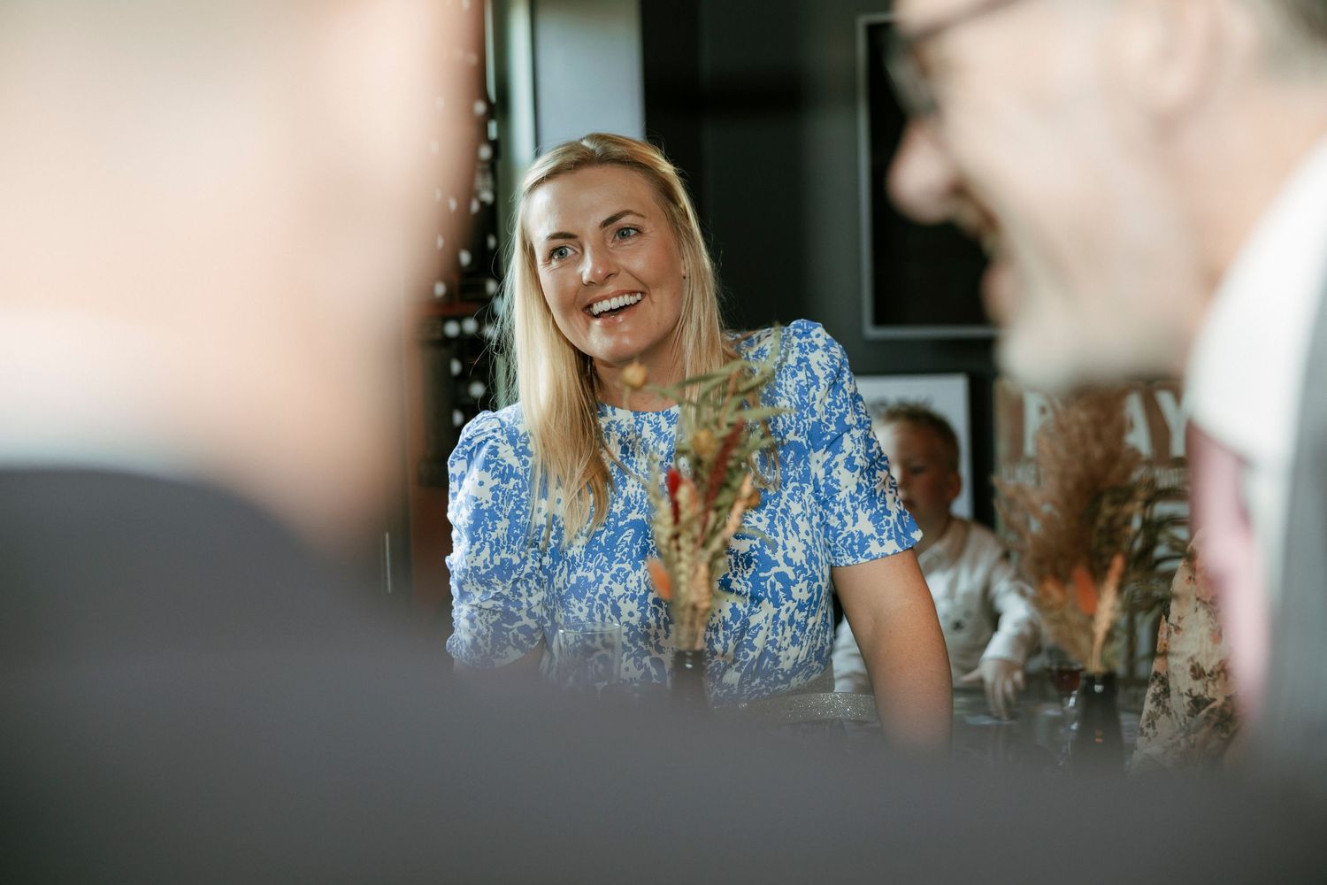 A cheerful conversation happening at a social gathering in soft lighting.