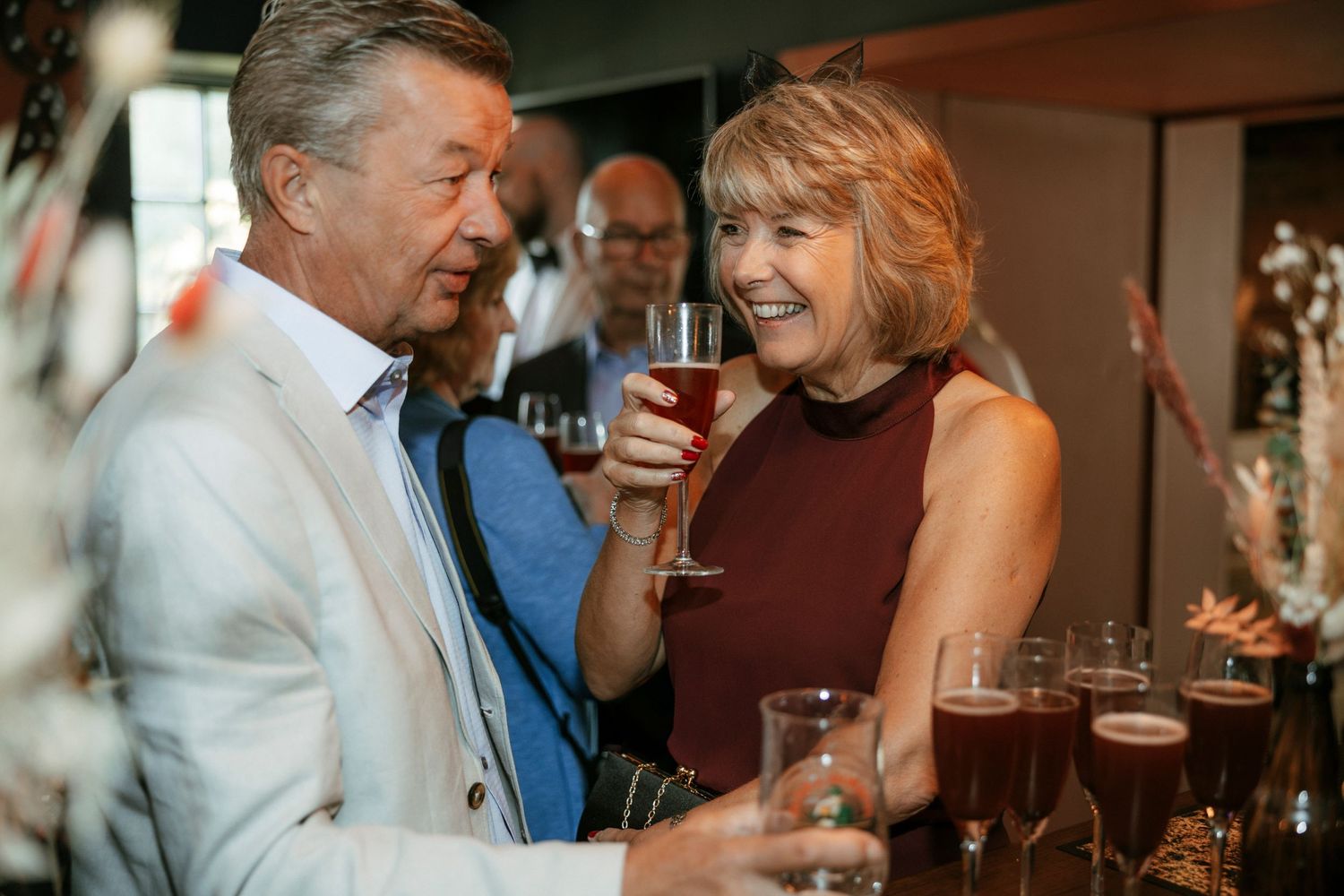 A couple shares drinks and conversation at an evening social gathering.