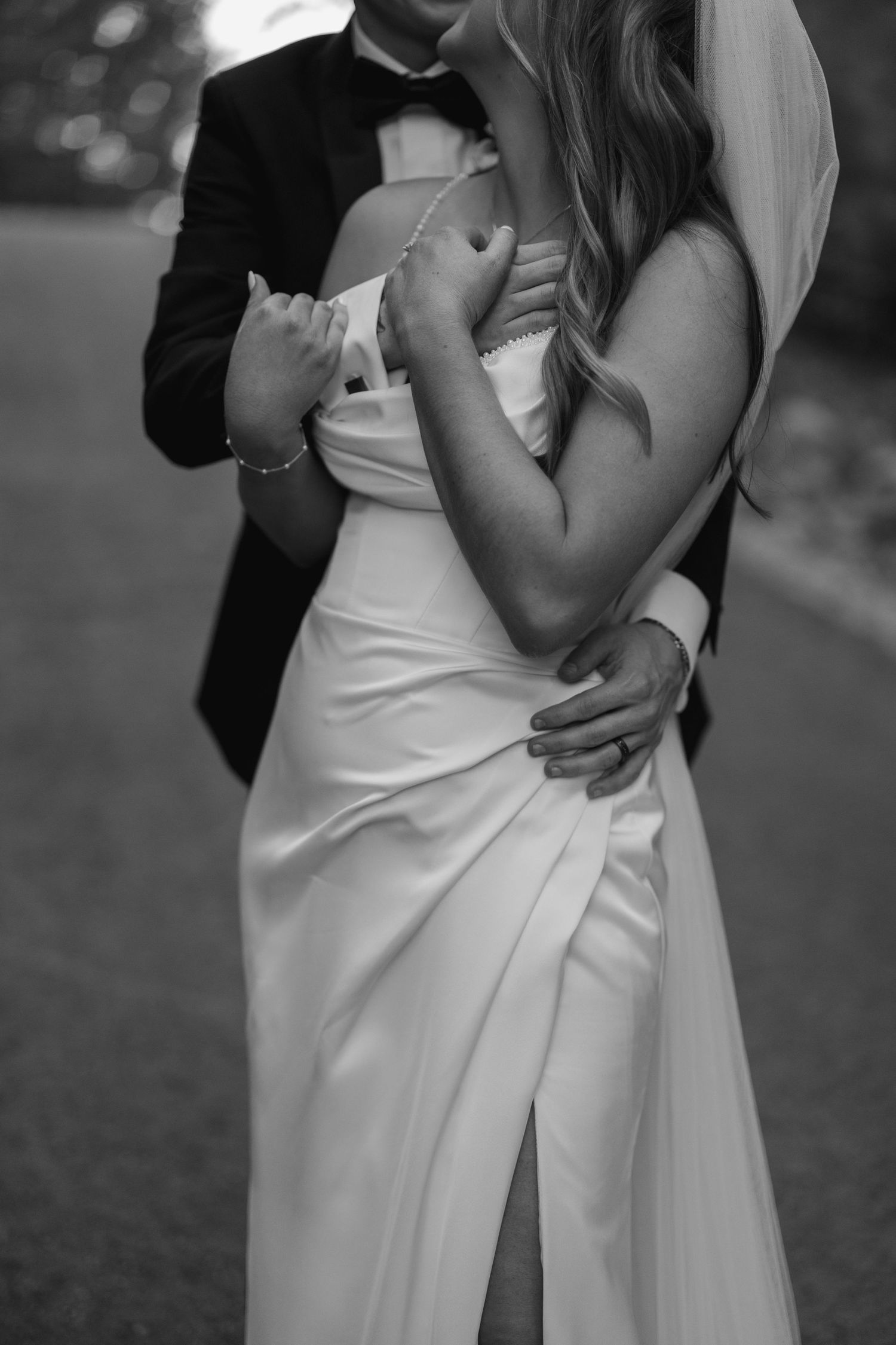 Shoulder down shot of a groom holding his bride in an embrace in black and white