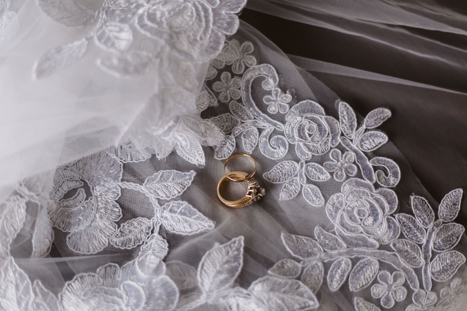 Gold ring sitting on a intricate-lace white vail