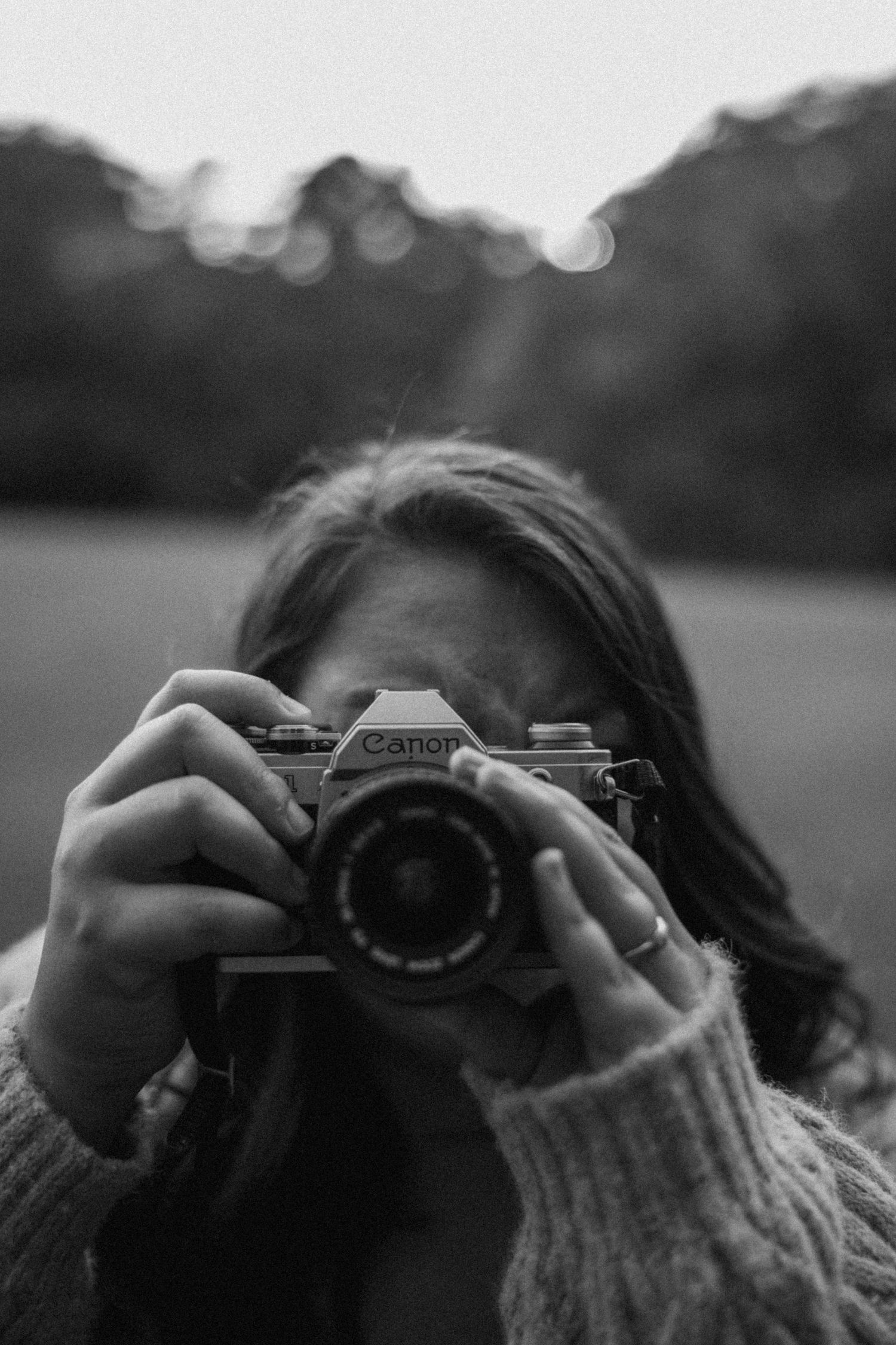Jamee, Georgia Photographer peering through the view finder of an antique Canon film camera