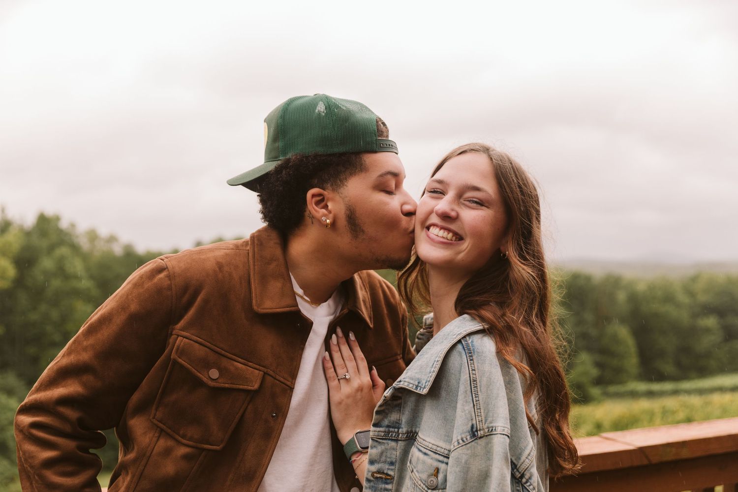 Man kissing his fiancee on the cheek