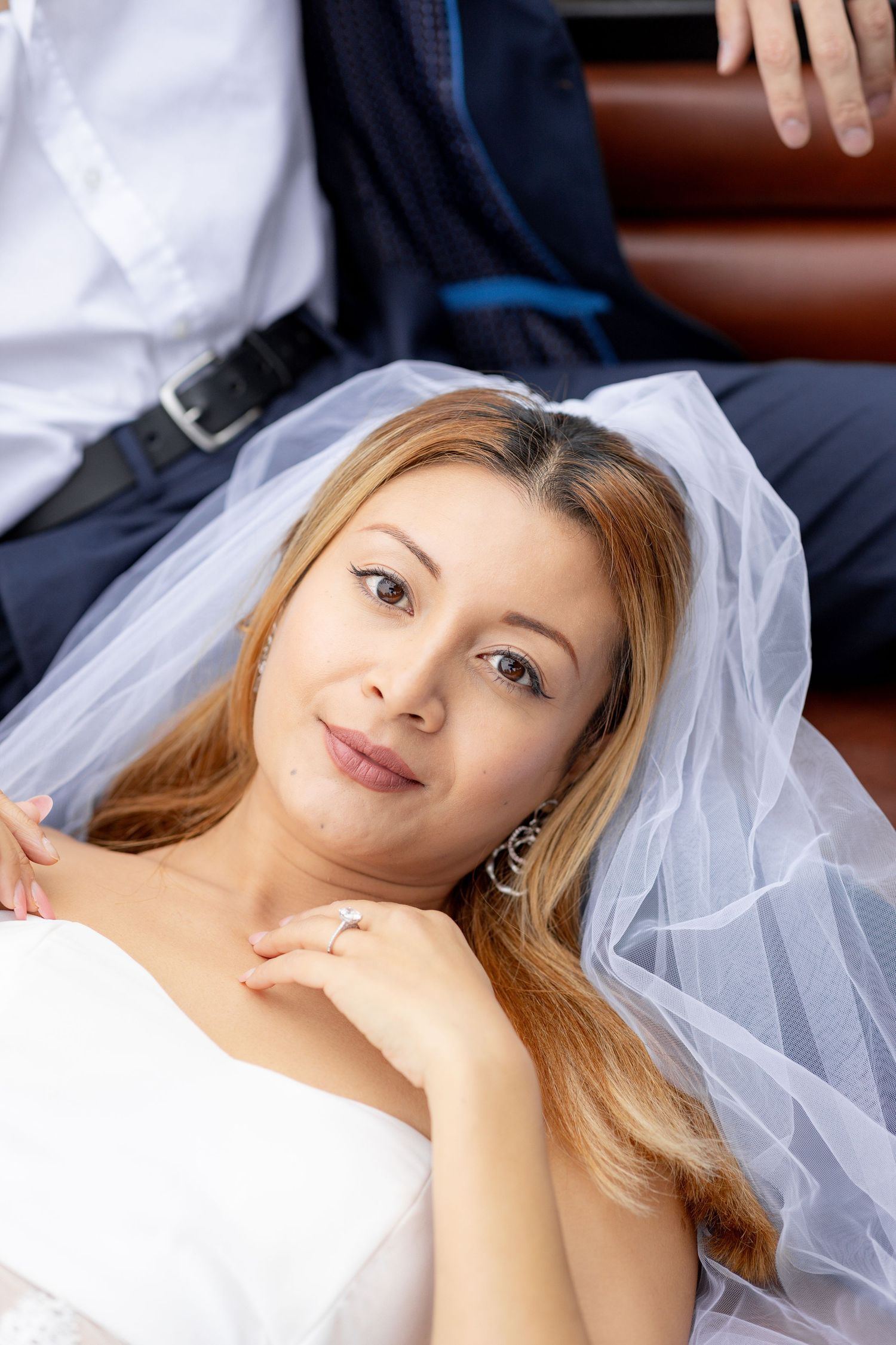 Close up portrait of bride wearing white veil and natural makeup.