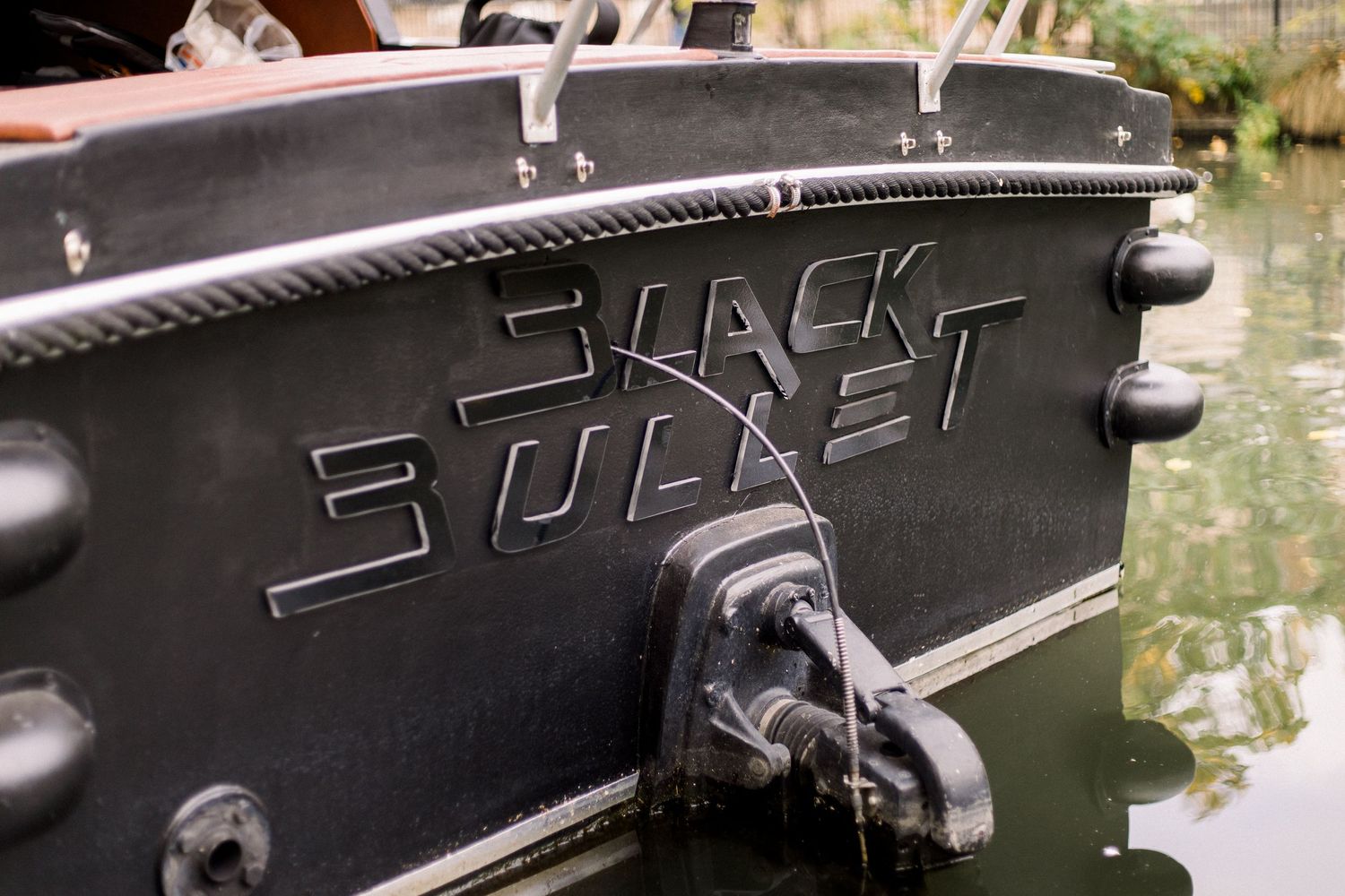 A close-up view of black text engraved or etched into a dark metal surface.