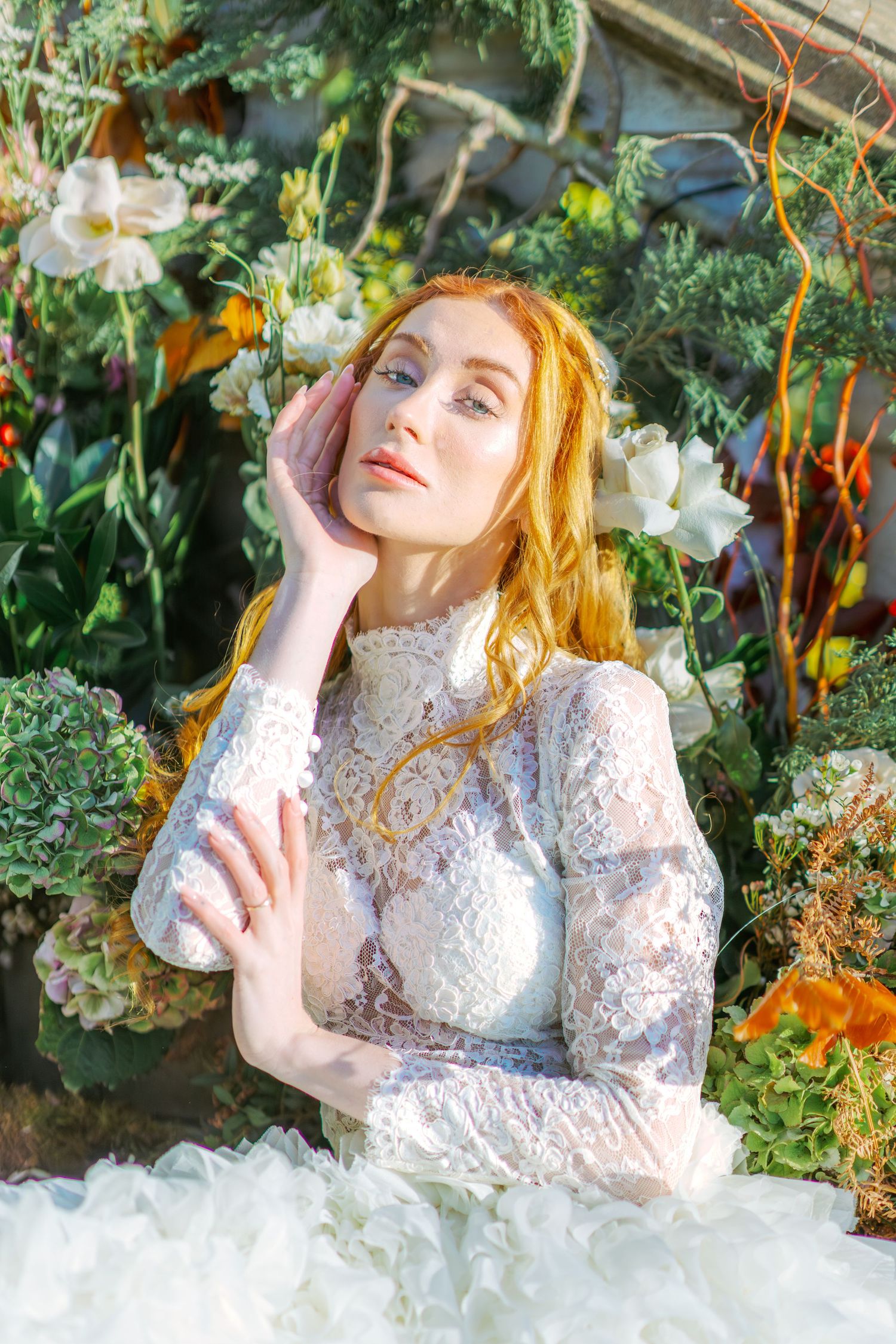 Dreamy garden photoshoot featuring white lace dress and floral surroundings.