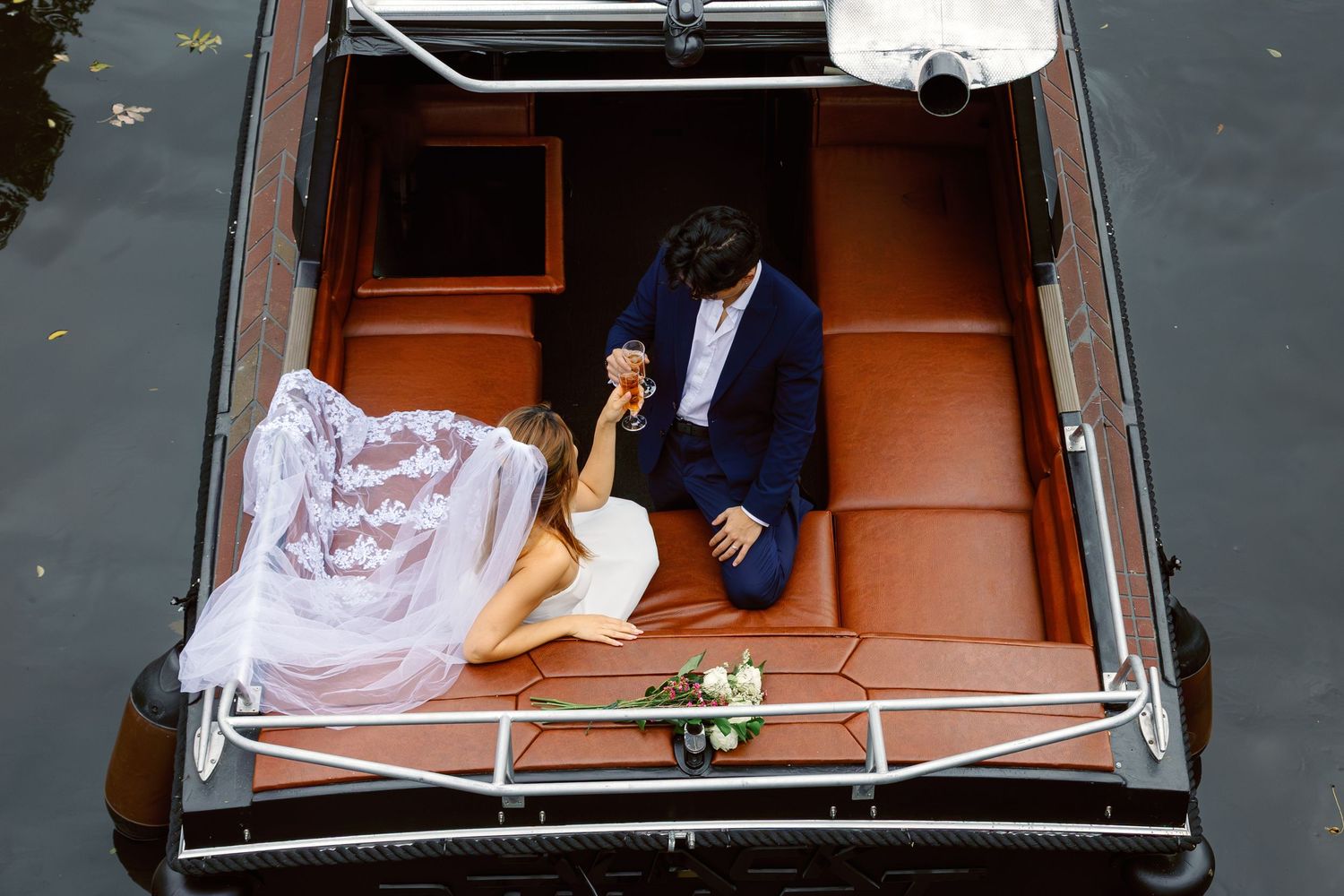 A person sleeps inside a wooden coffin with white interior padding and satin lining during a unique funeral service.