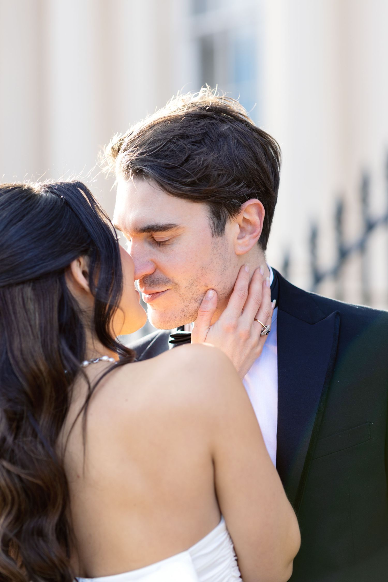 A romantic wedding couple shares an intimate kiss outdoors during their special day.