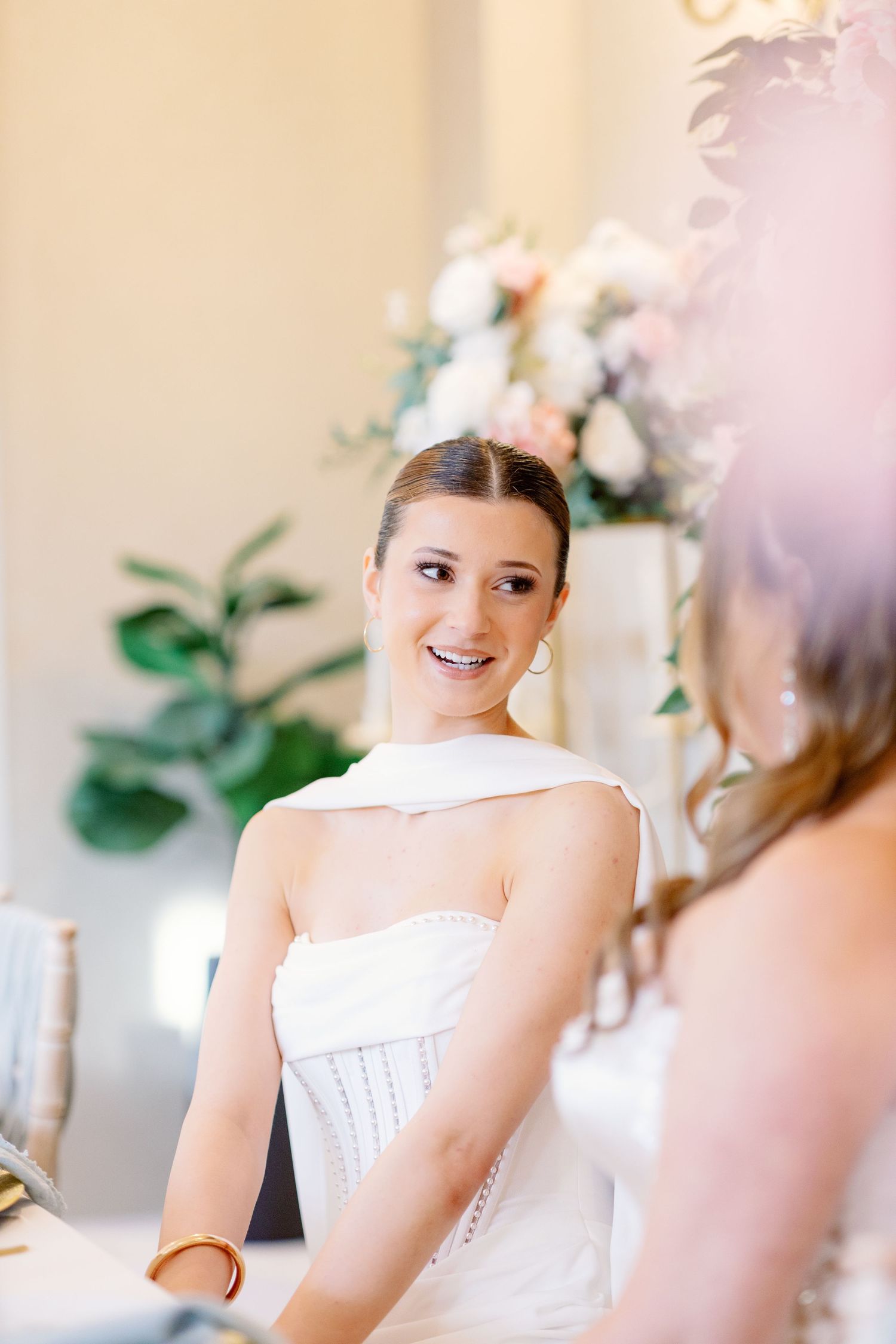 White formal gown with corset detail photographed in soft natural lighting.