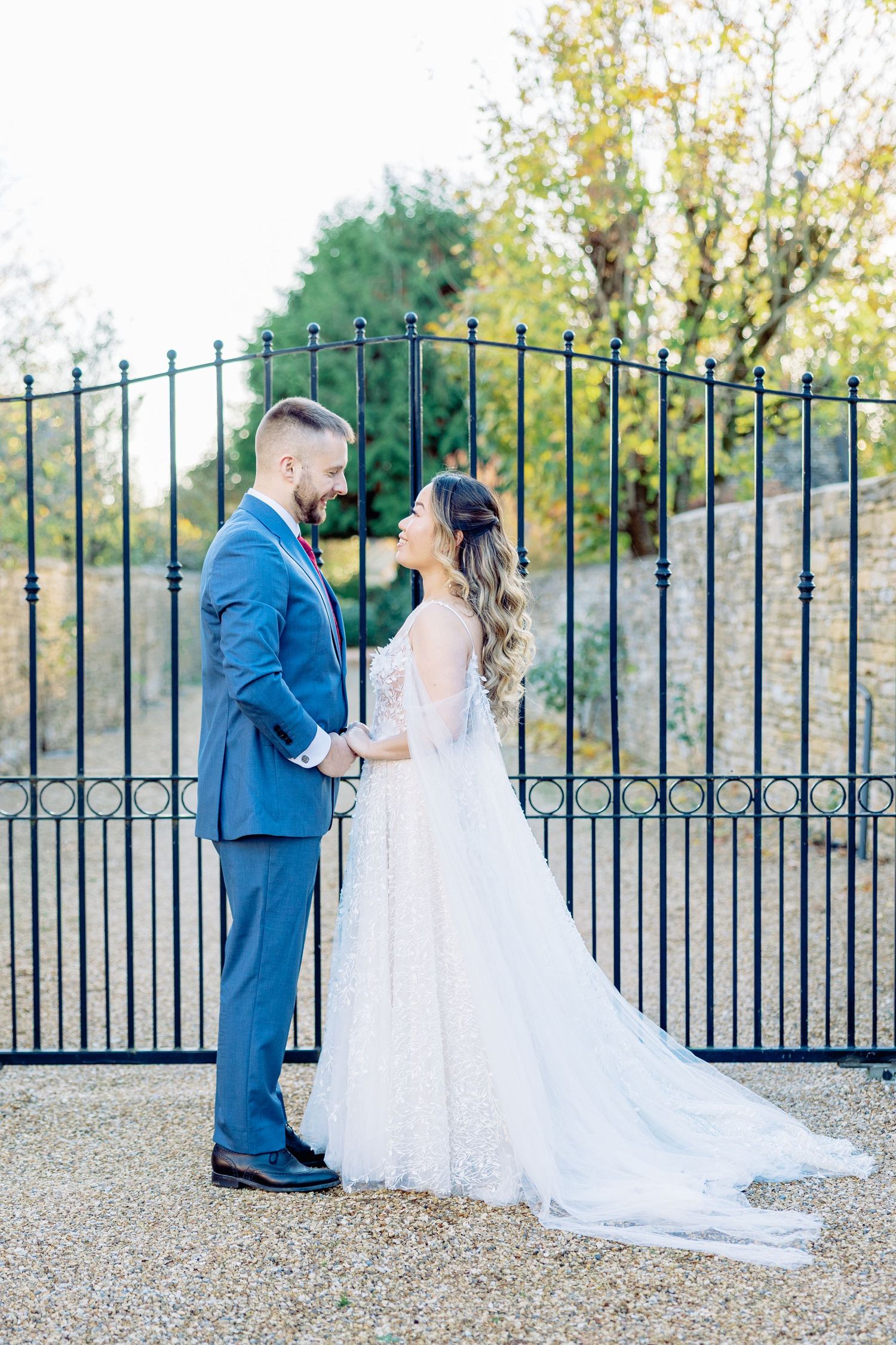 Wedding couple sharing romantic moment by decorative iron gates.