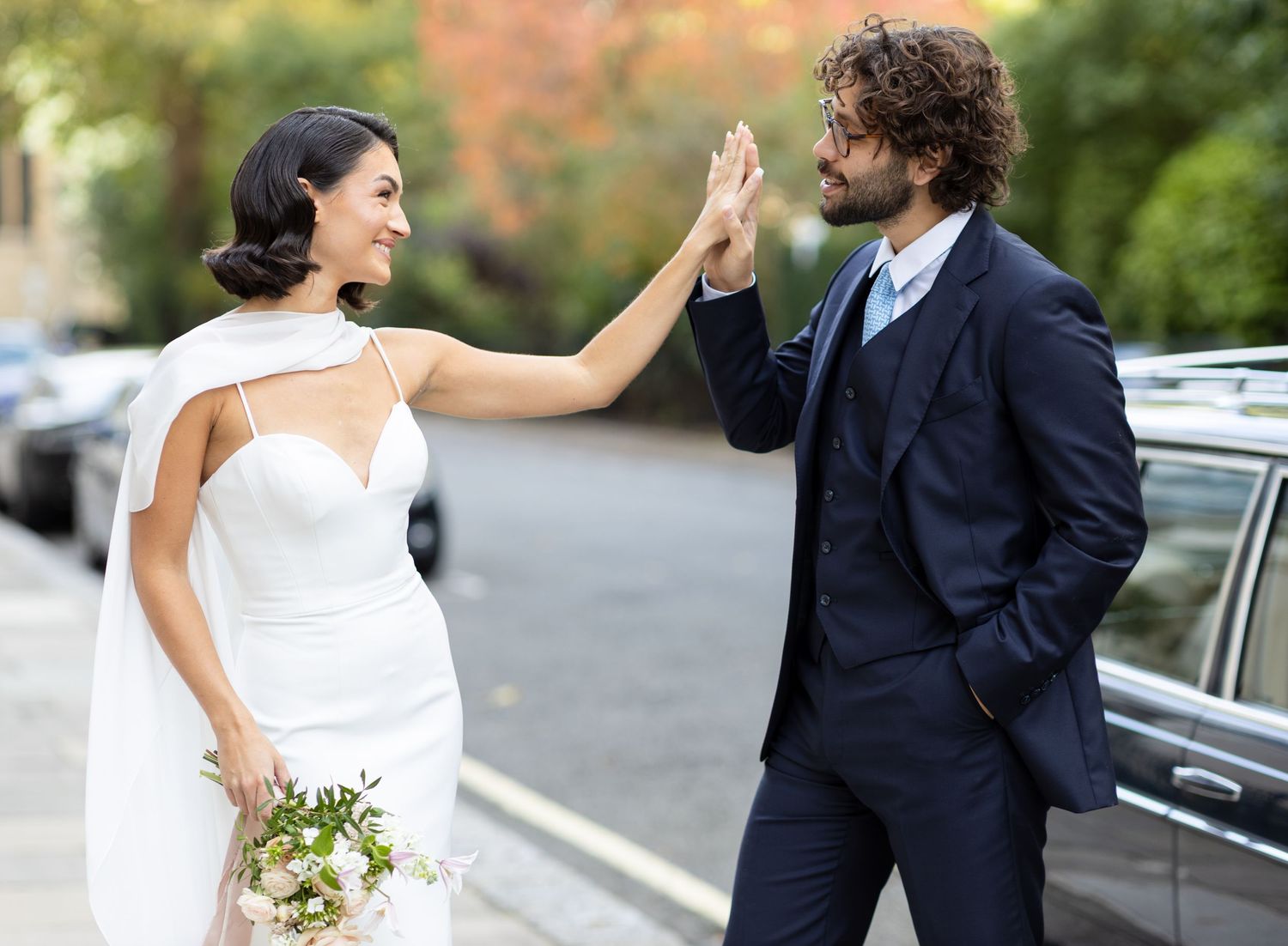 A playful wedding photoshoot with the couple posing outdoors.