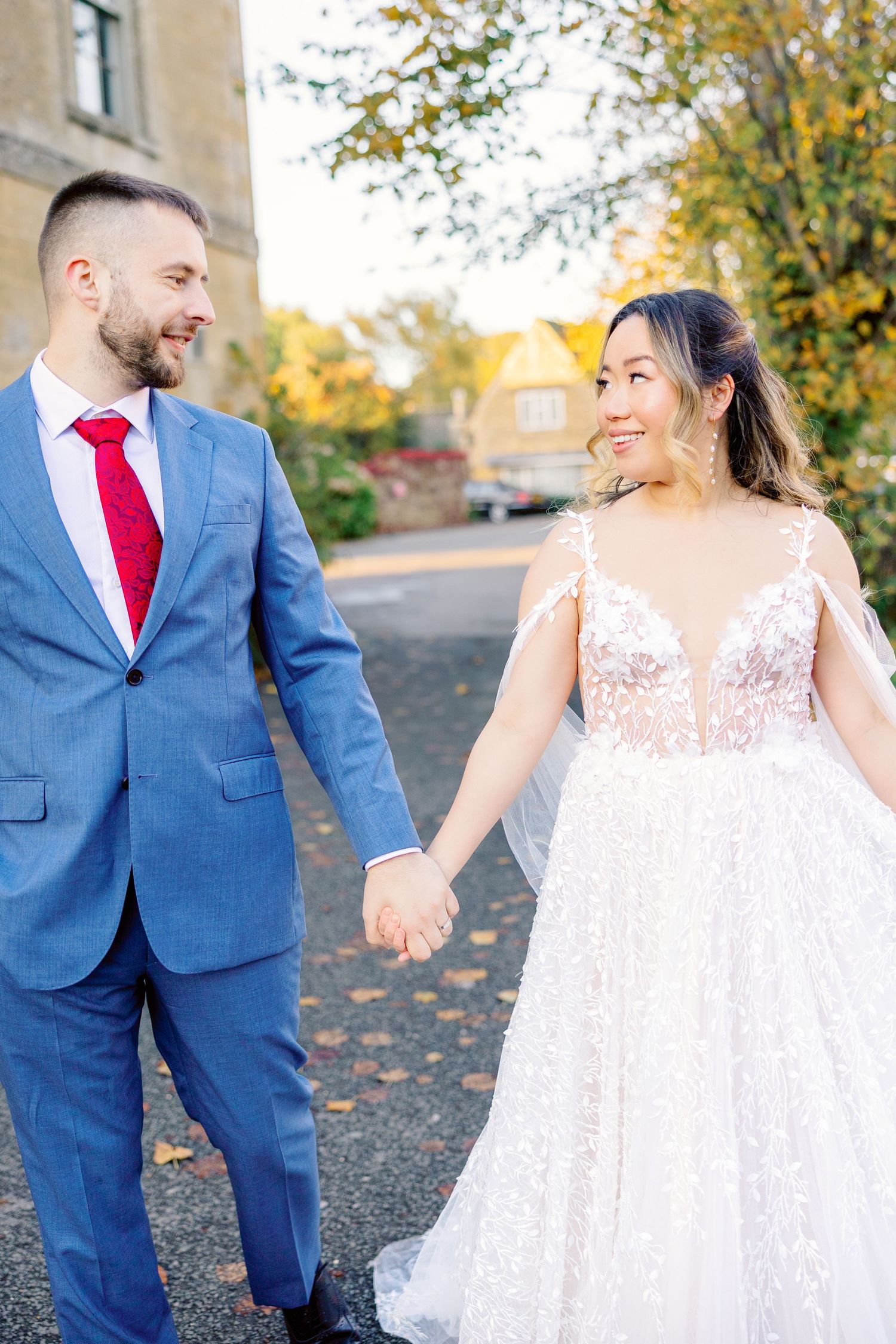 Romantic wedding photos showing couple in blue suit and lace dress against autumn scenery.