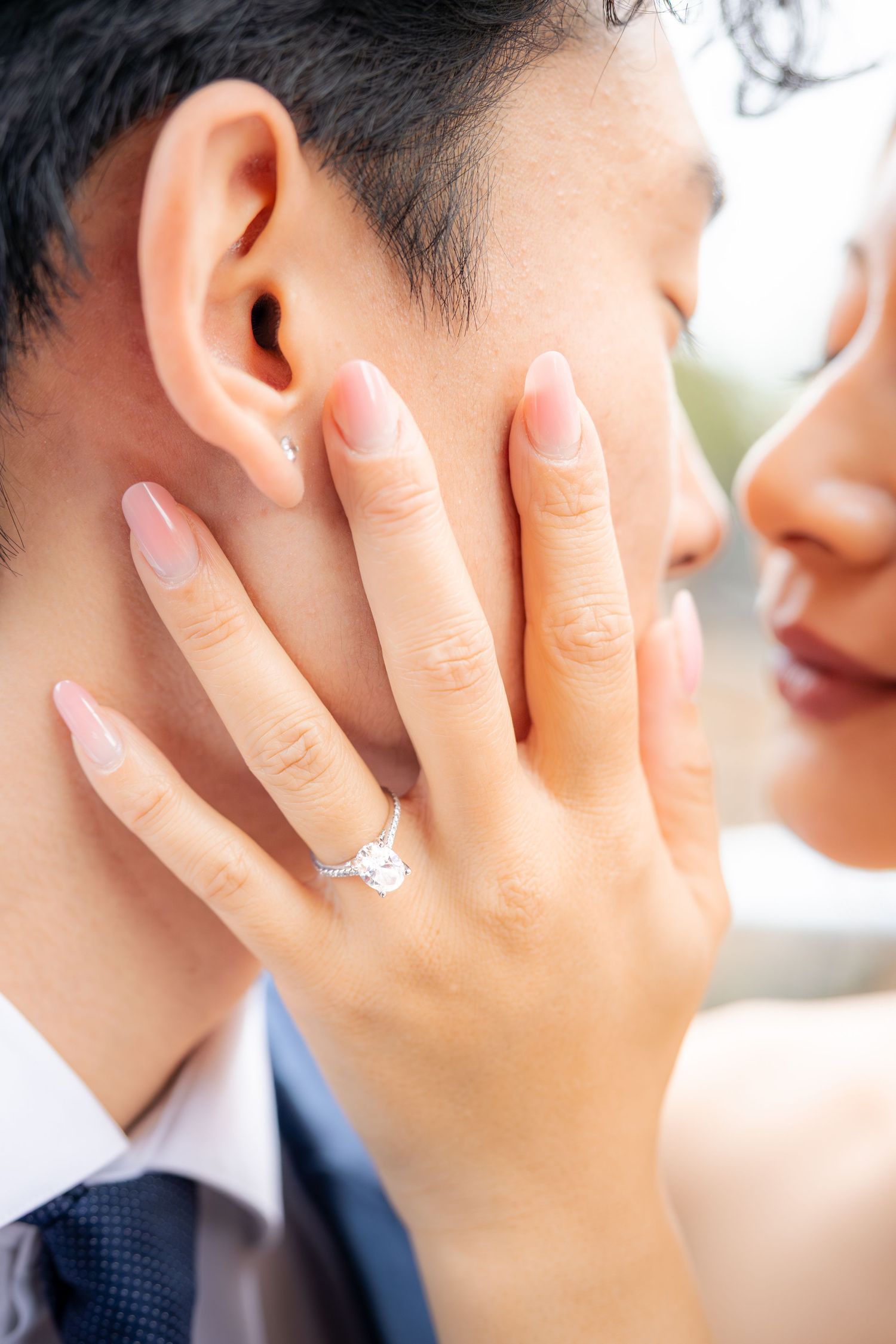 Close-up of an engagement ring as couple shares an intimate moment.