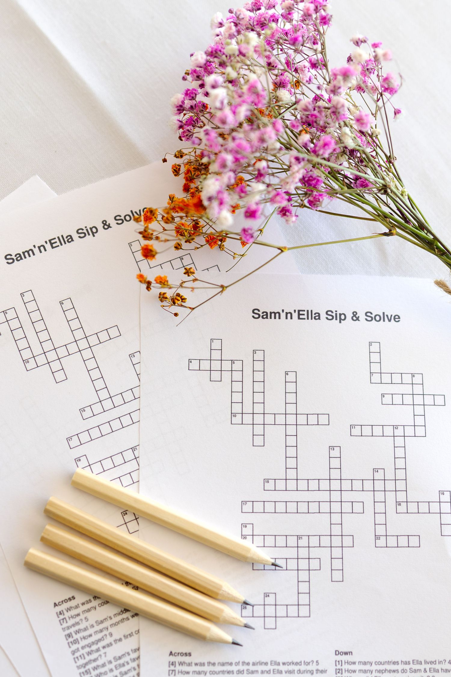 Wedding crossword puzzle game Sam n Ella Sip and Solve with pencils and pink dried flowers decoration.