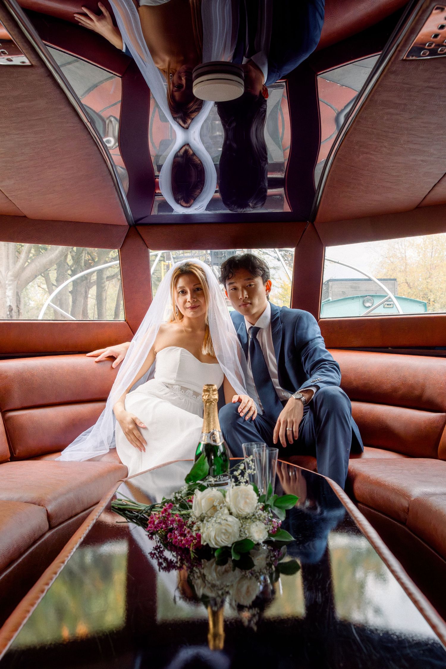 A couple in wedding attire shares intimate moments on brown leather seats inside what appears to be a luxury vehicle.
