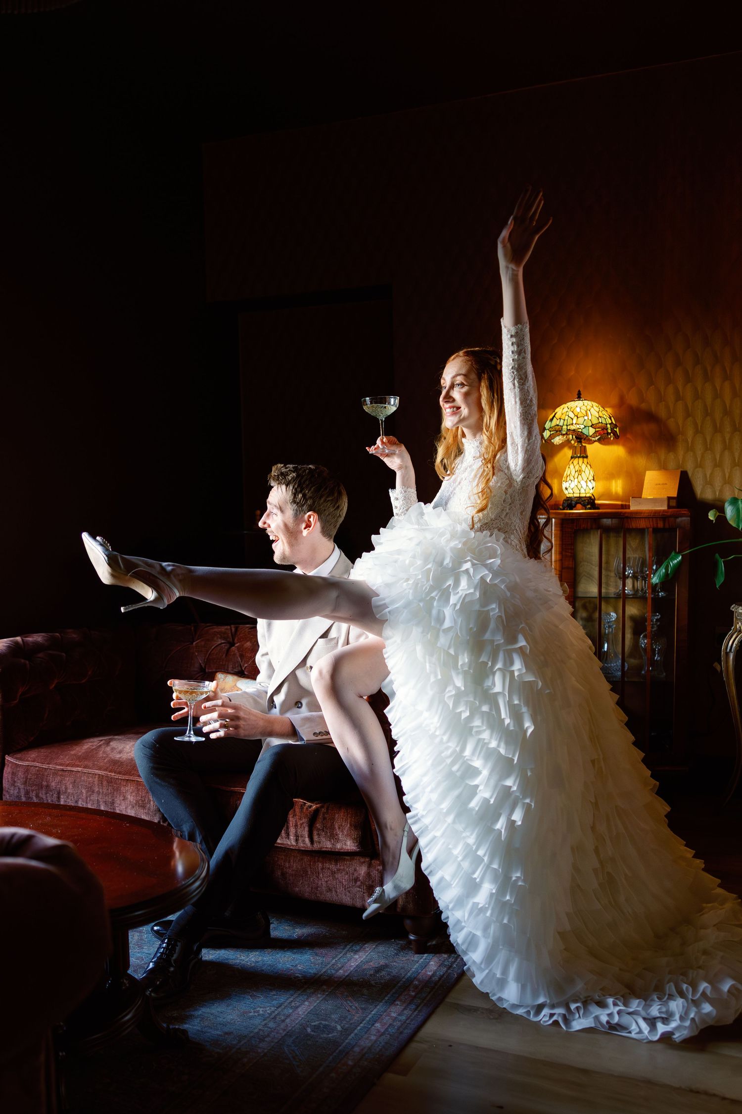 Artistic wedding portrait series showing couple in formal attire seated in dimly lit vintage room.