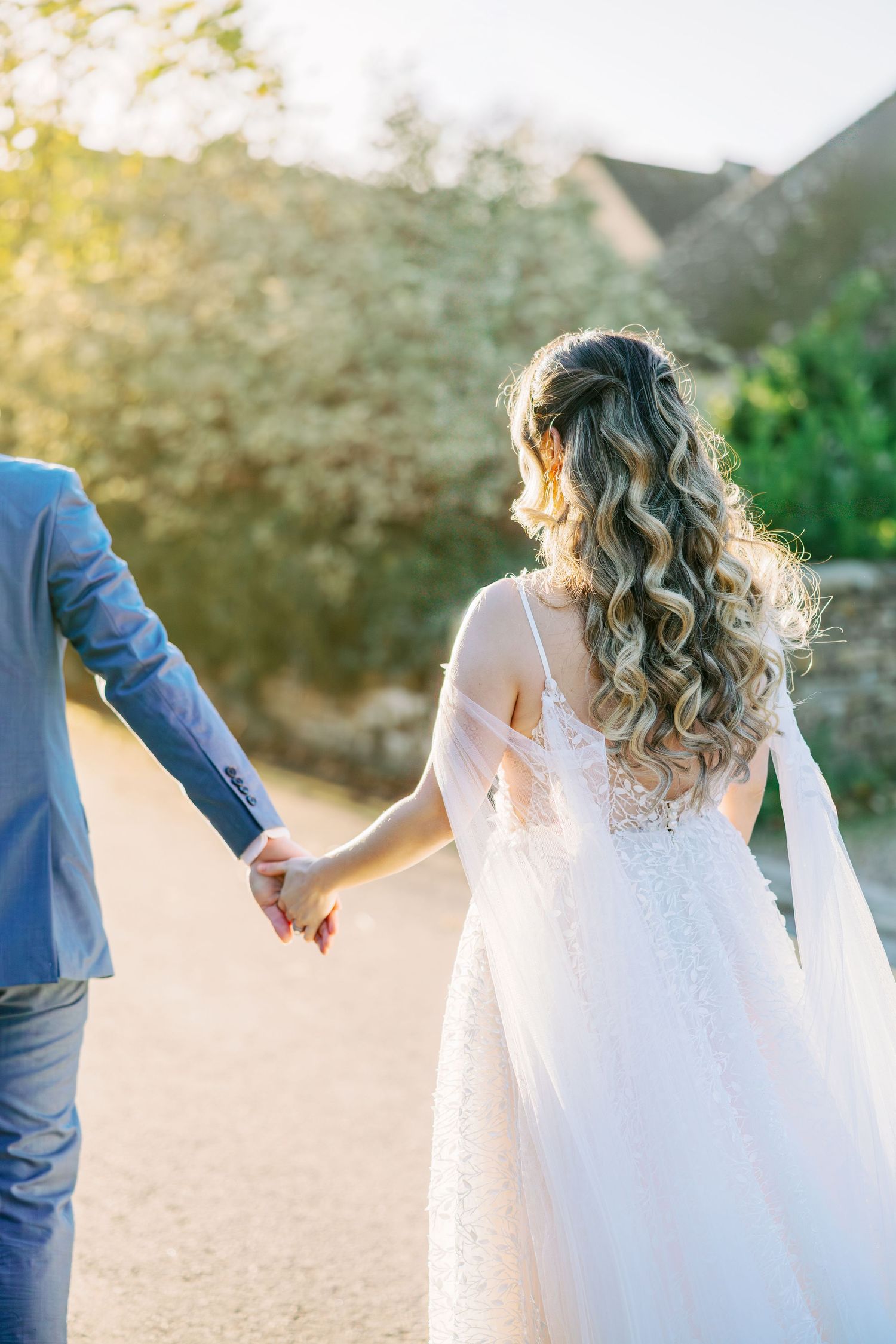 Bride in lace dress twirls during sunset wedding photoshoot.