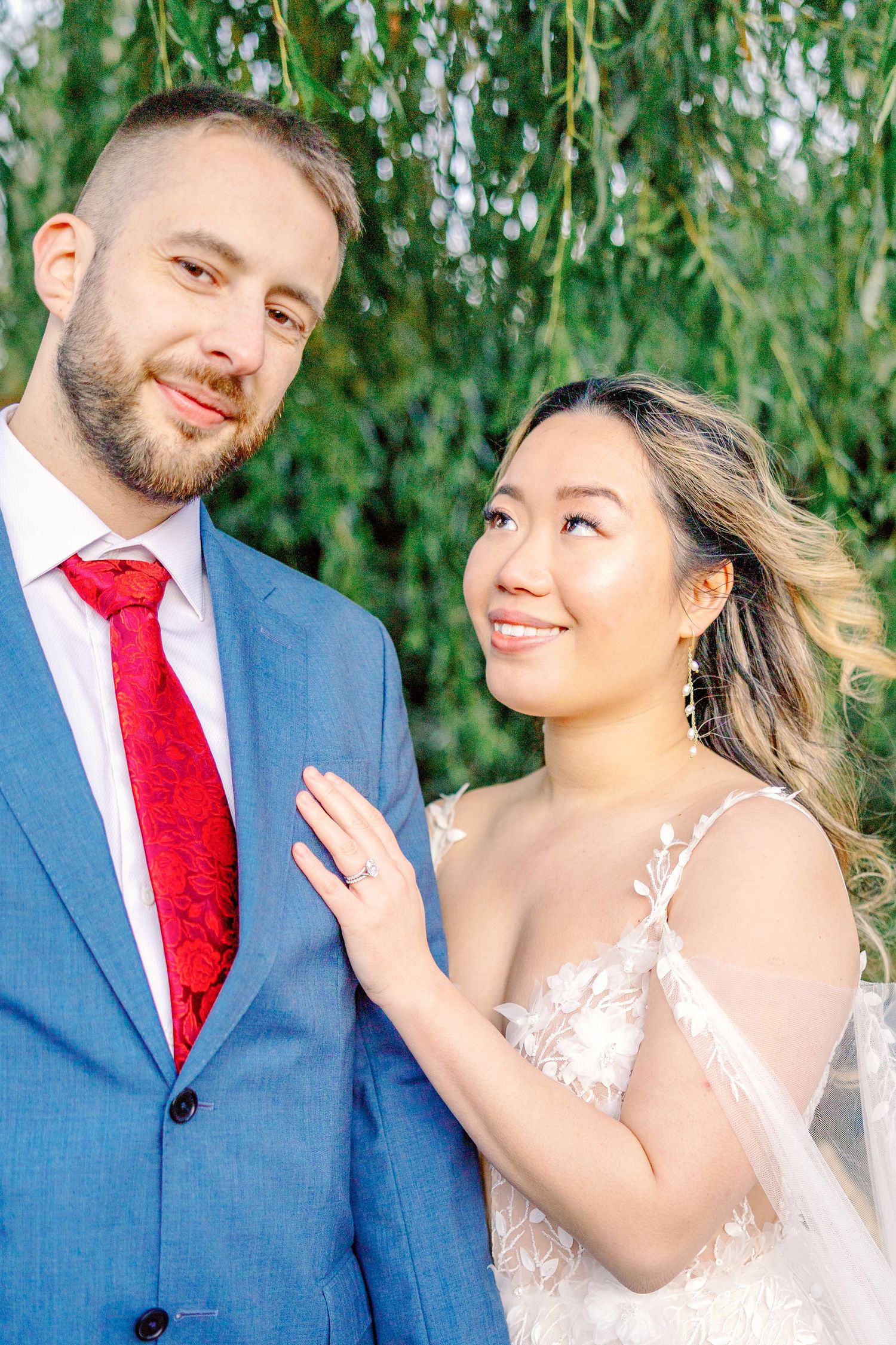 Romantic wedding portraits under weeping willow tree with soft lighting.
