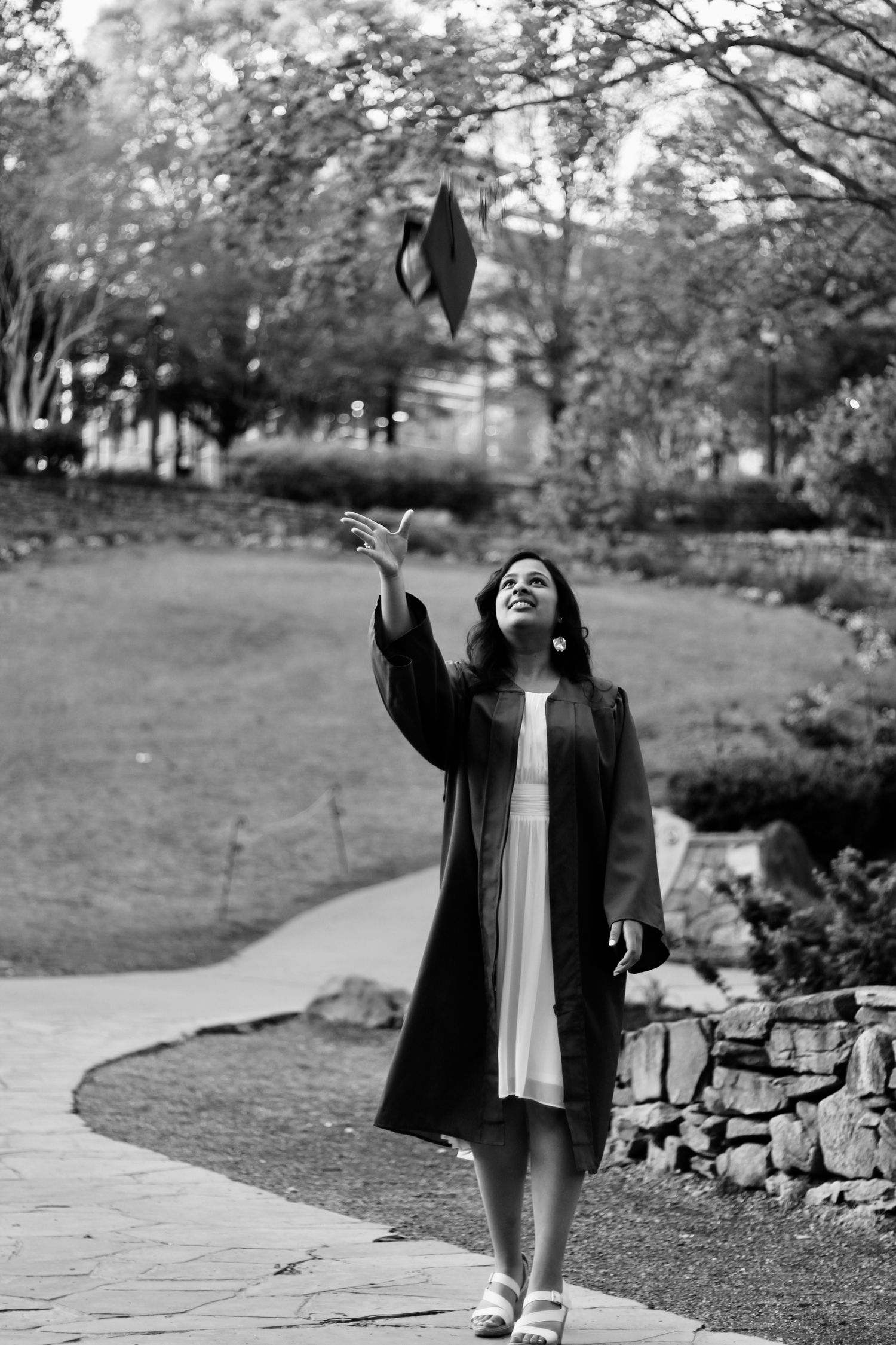 A senior girl throwing her cap into the sky.