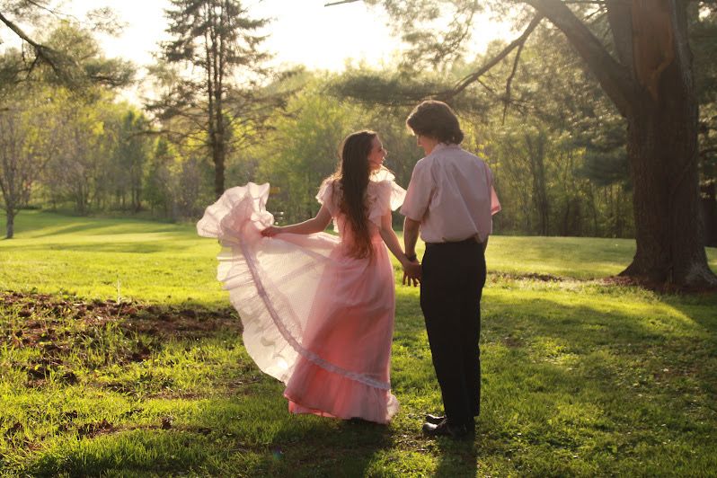 She twirls her skirt as she smiles at her fiance.