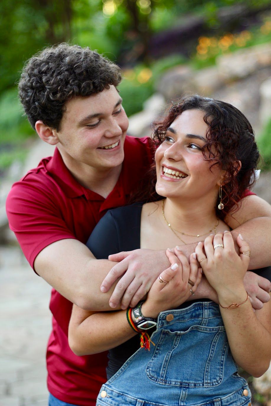 A boyfriend & girlfriend look at each other hugging with big smiles.