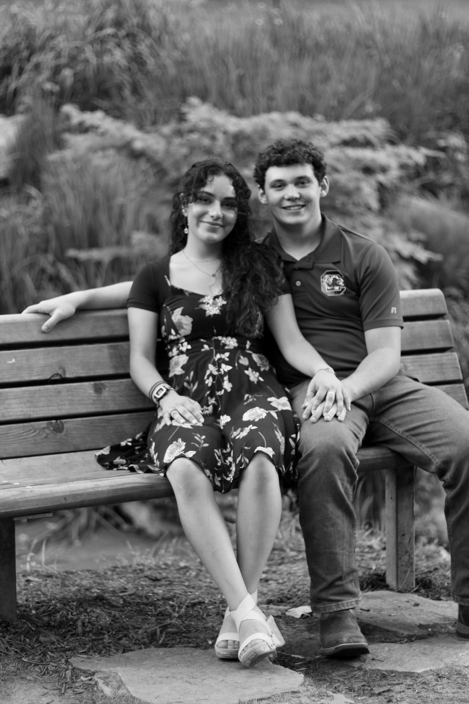 Holding hands on a park bench in Falls Park.