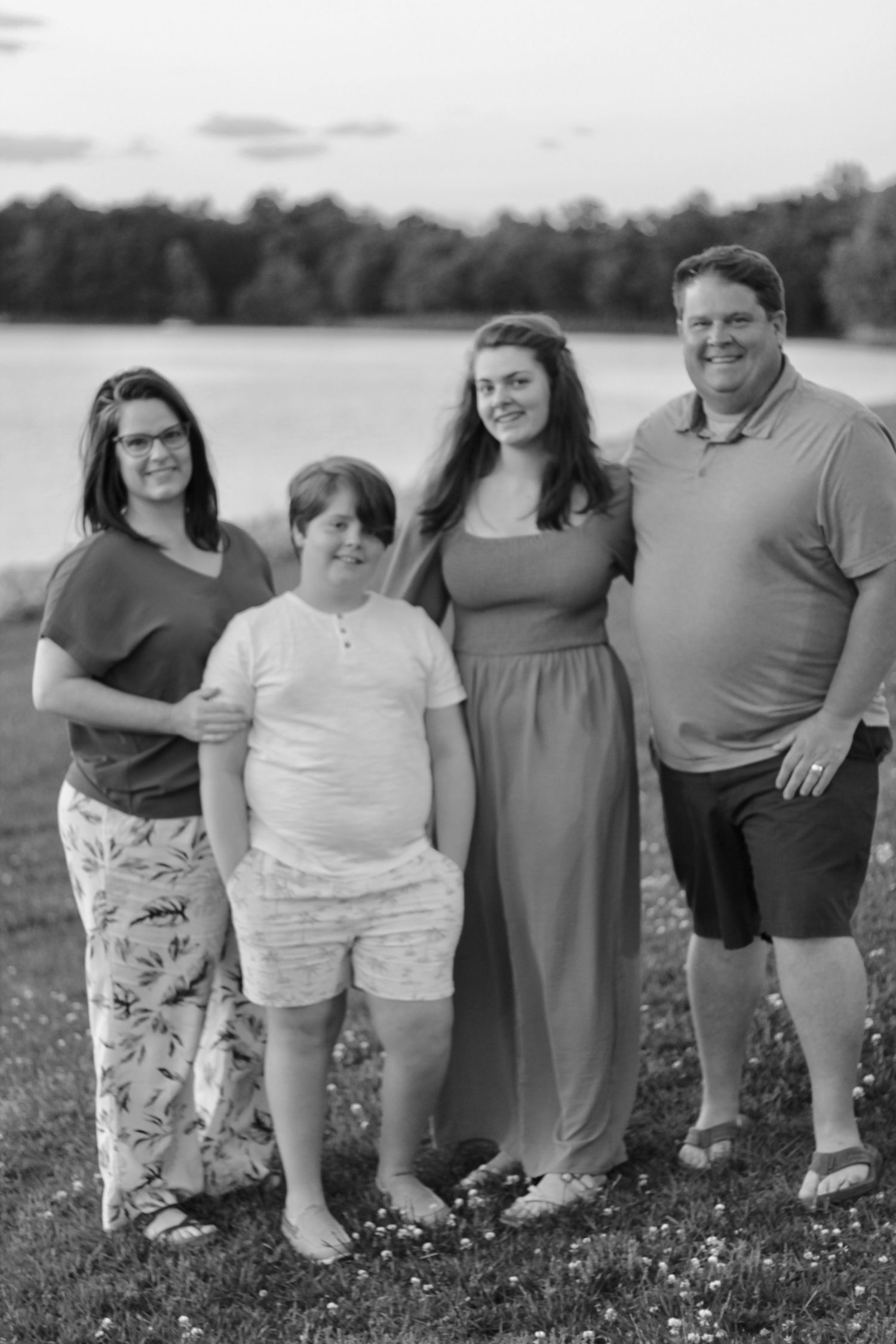 Beautiful family poses for the camera in front of gorgeous Lake Robinson.