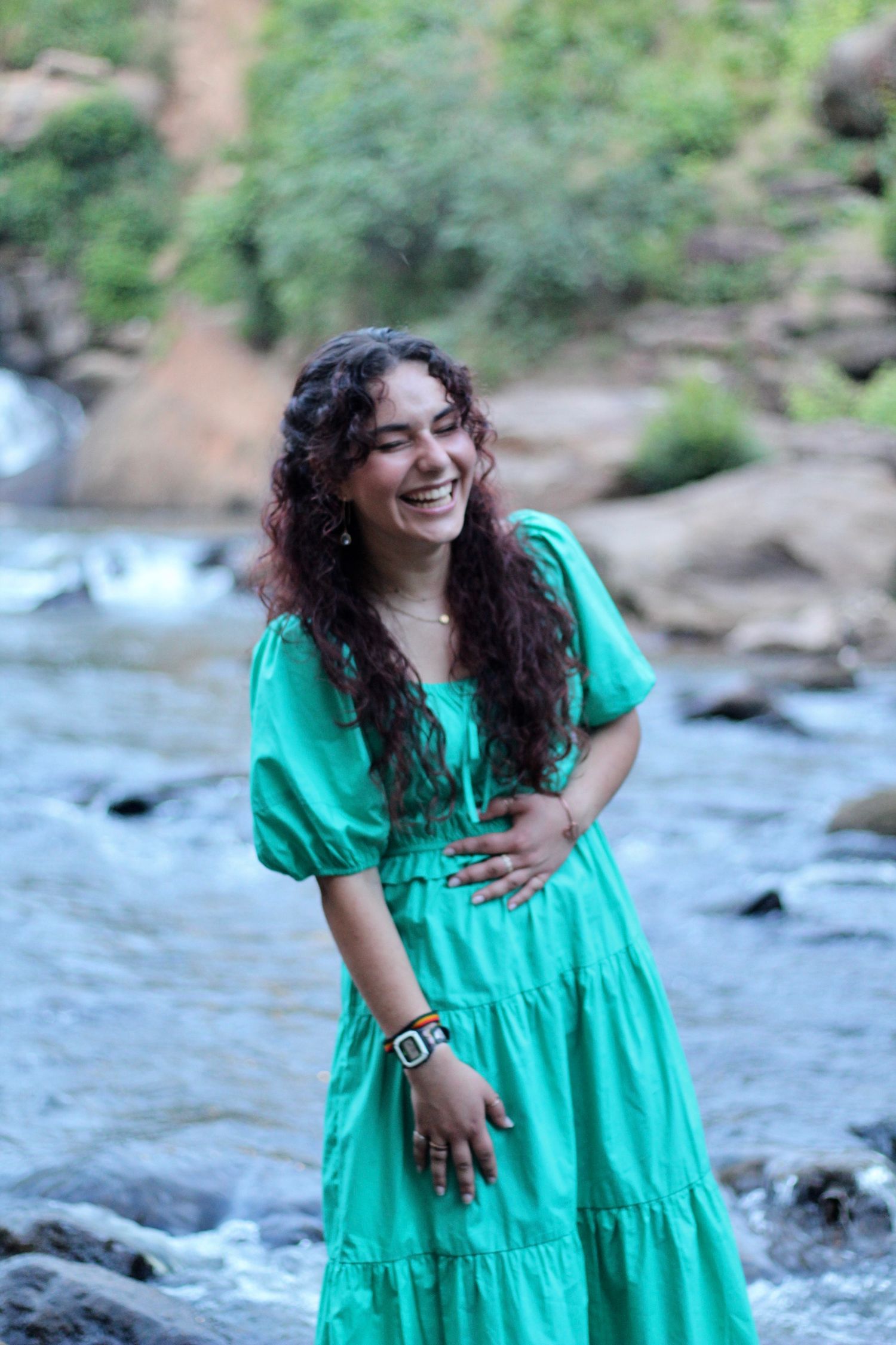 She's laughing as she stands in the Reedy River in Falls Park.