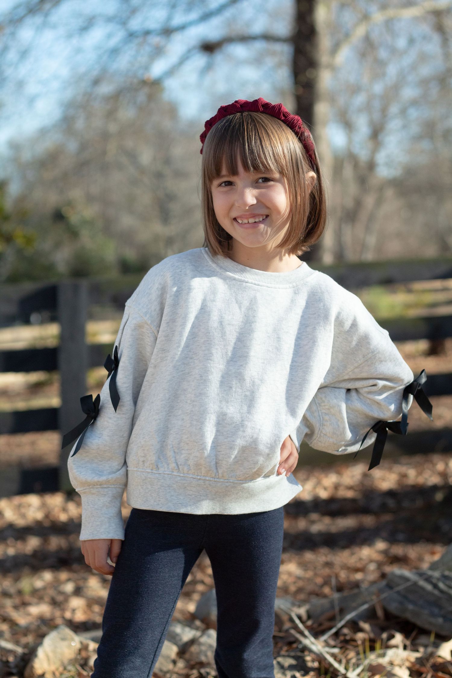 This little lady's striking a glam pose, putting her hand on her hip as she smiles at the camera.