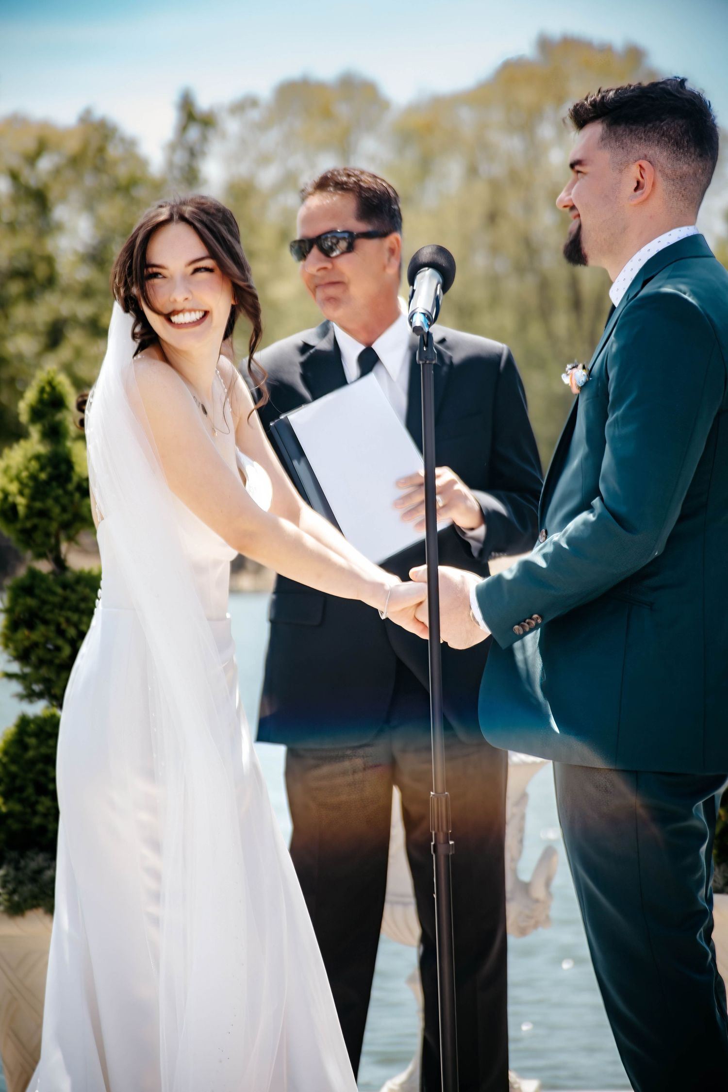 Joyful wedding ceremony moments captured by lakeside with natural lighting.