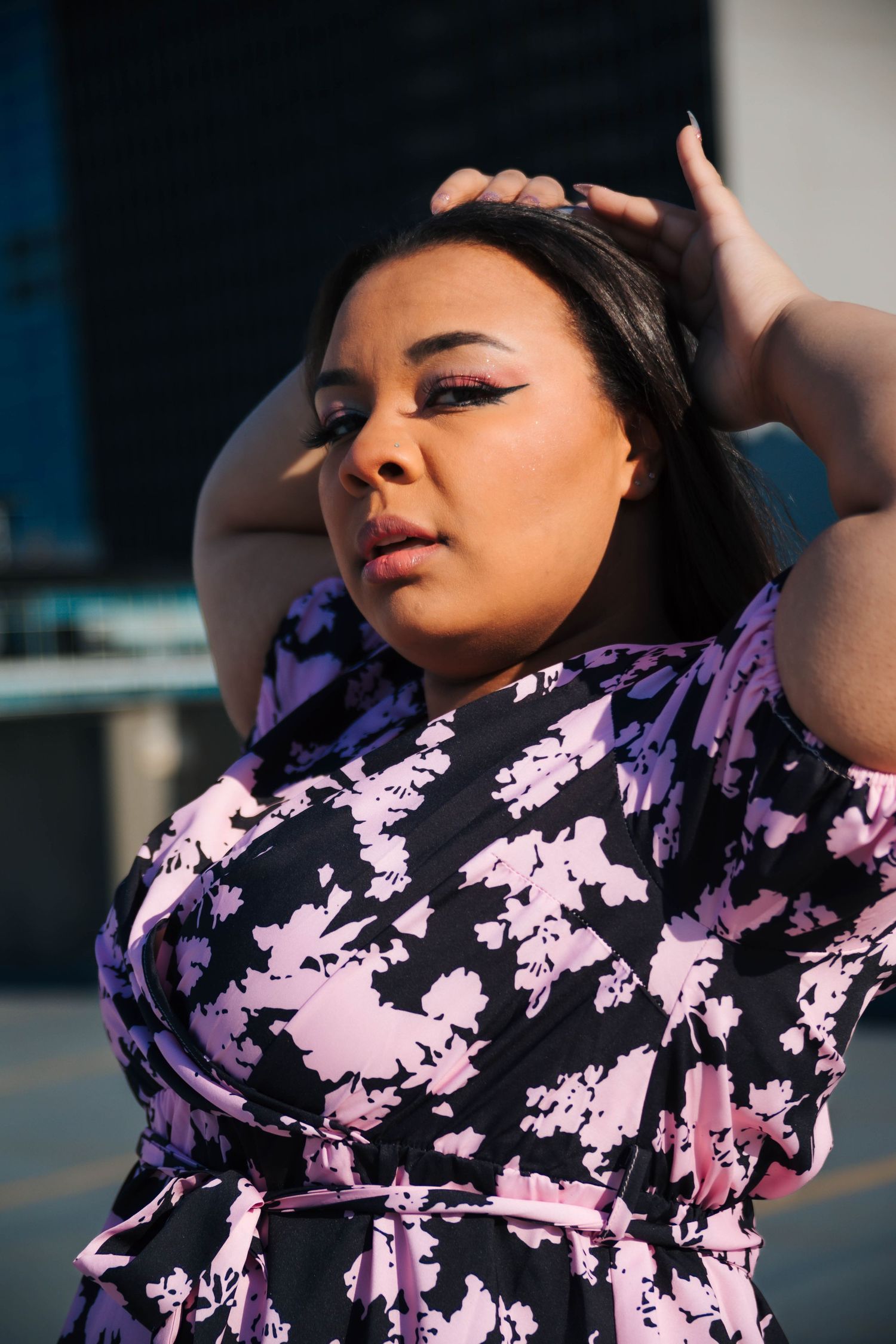 Fashion portrait in a pink and black patterned dress with dramatic lighting.