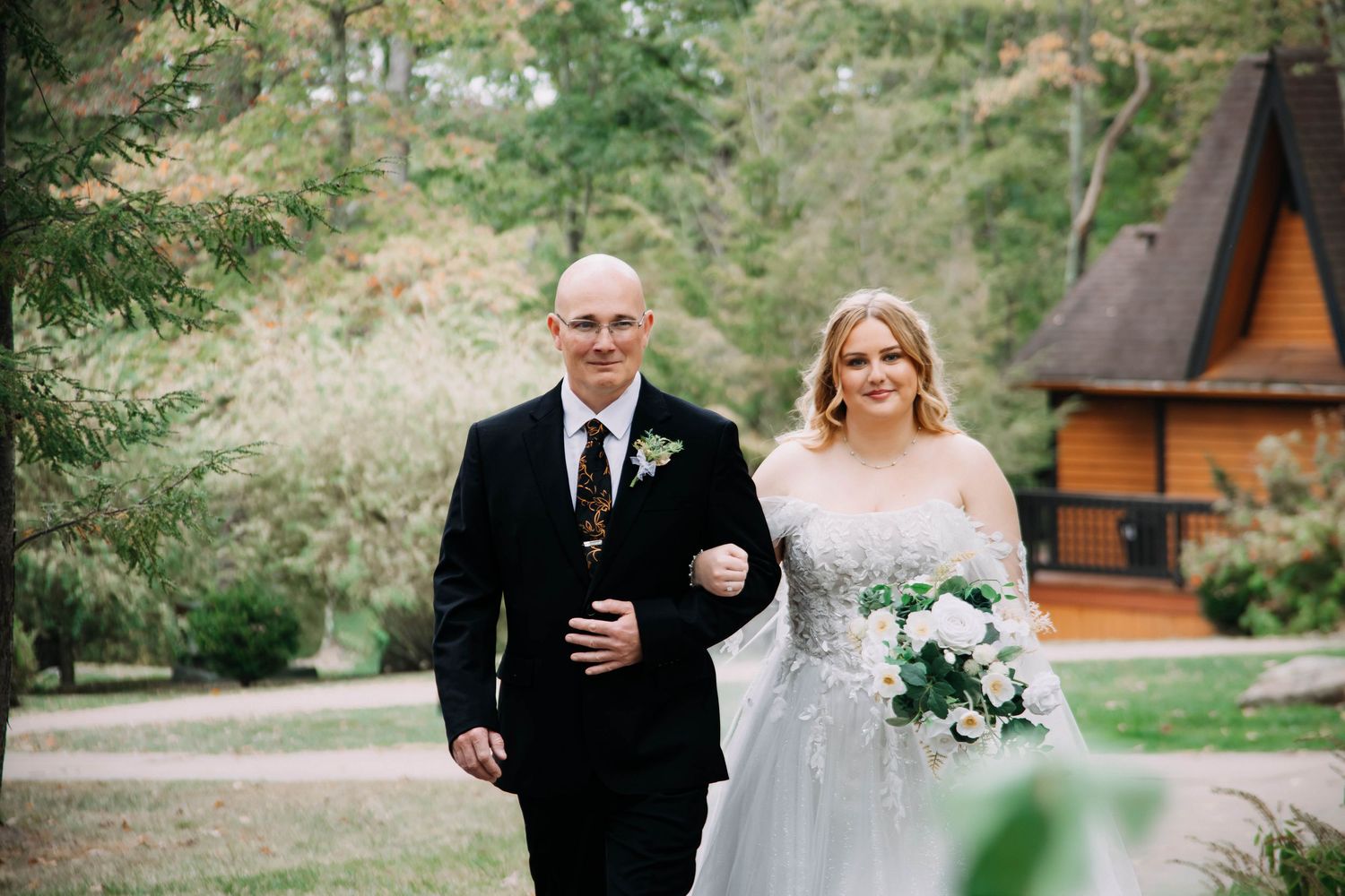 Outdoor wedding processional with floral bouquets and formal attire.