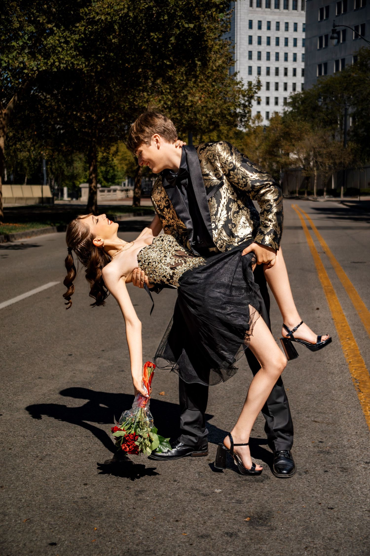 Stylish couple in urban setting creates dramatic dance-inspired poses on city street.