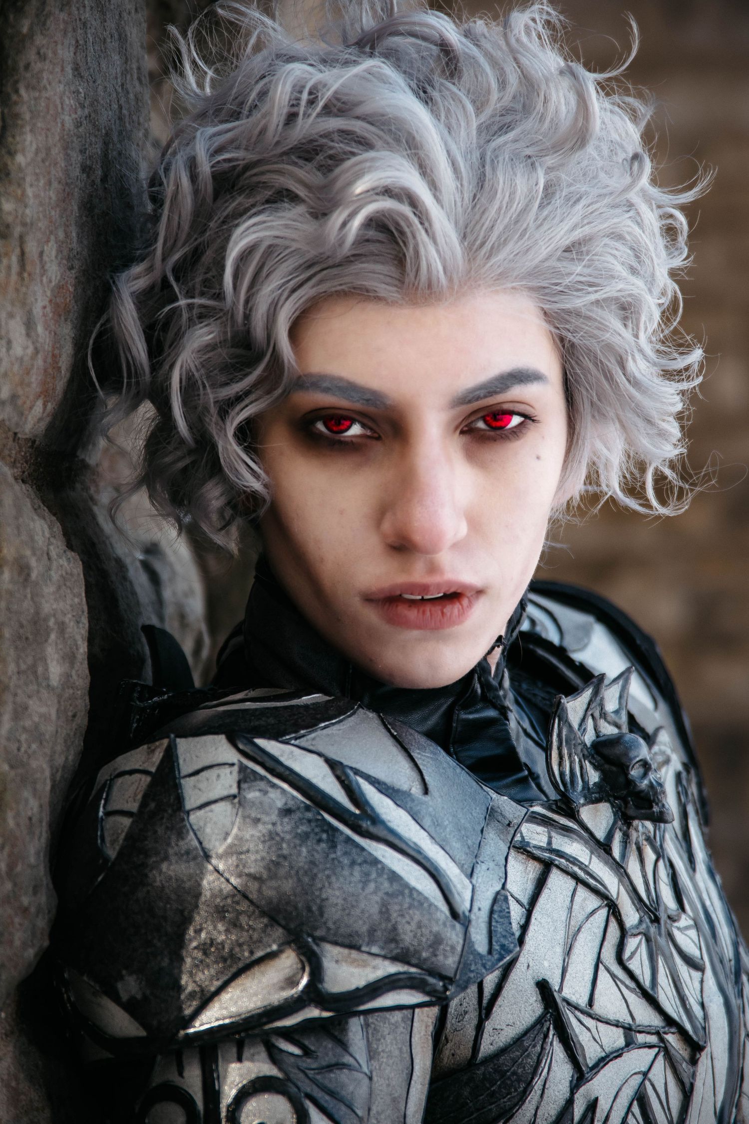 Gothic fantasy character with silver hair and metallic armor in dramatic lighting.