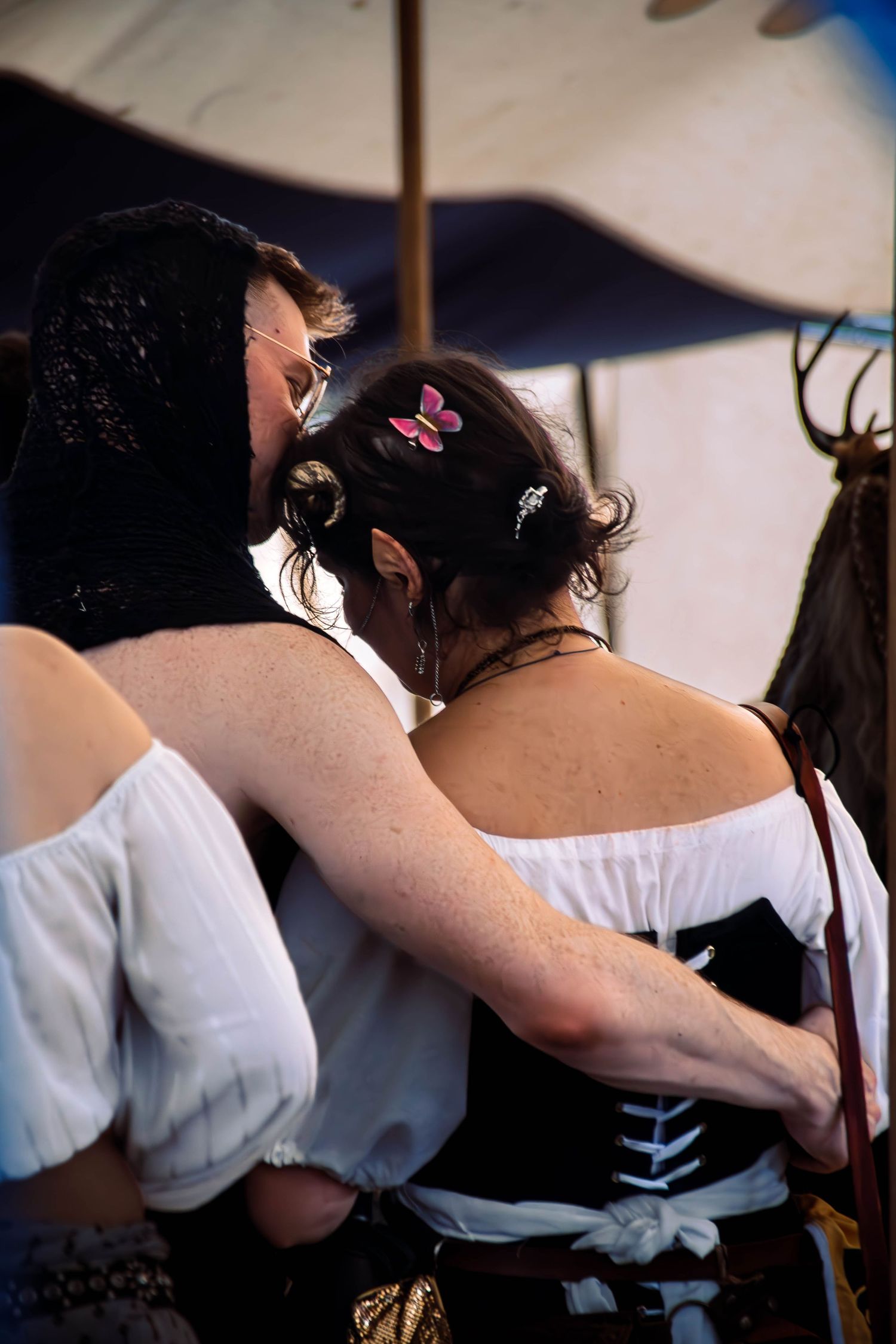 A sequence of images showing a woman in a white dress being laced up in a corset from behind.