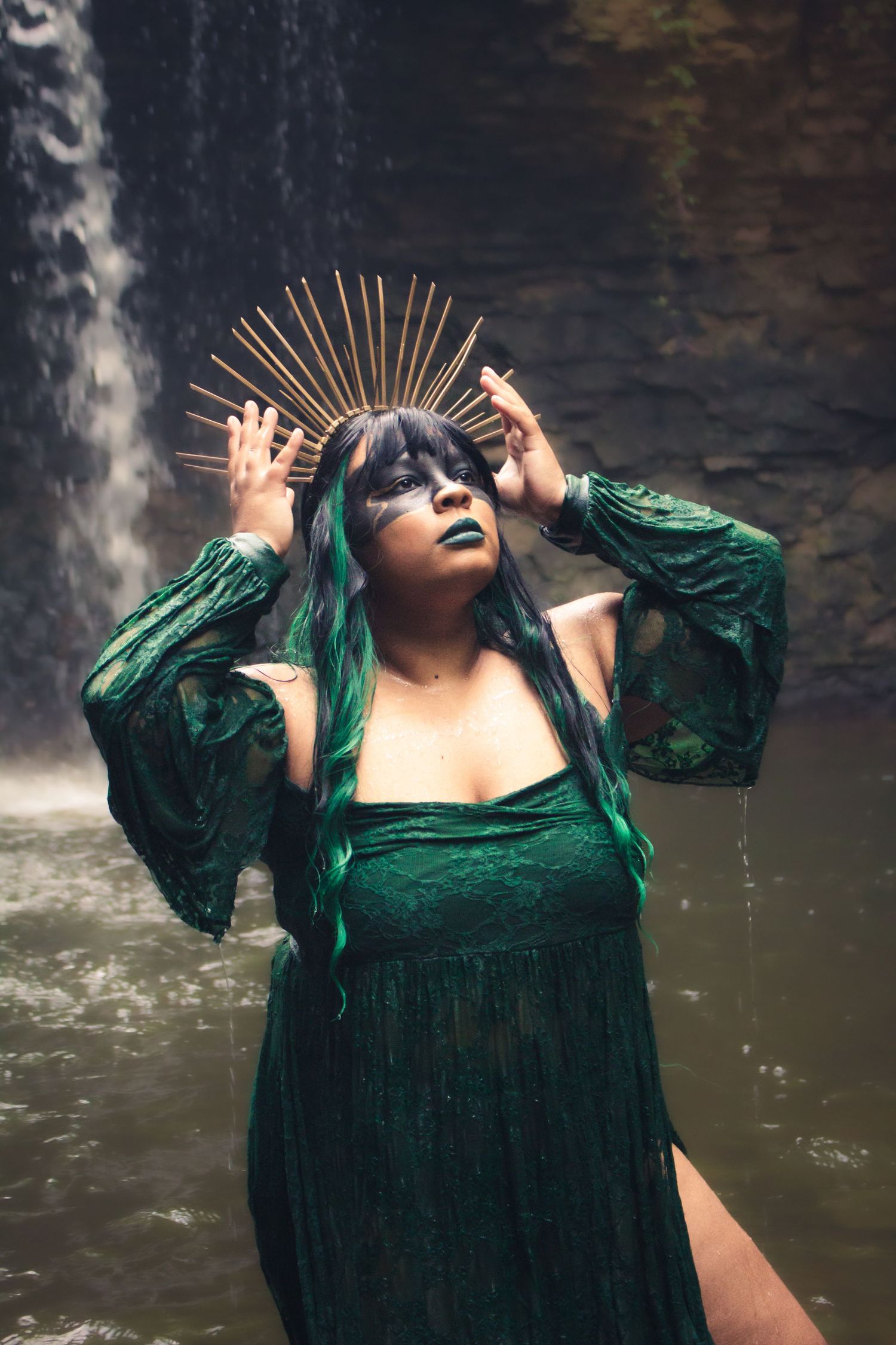 Dramatic portrait series in emerald velvet dress against a waterfall backdrop.