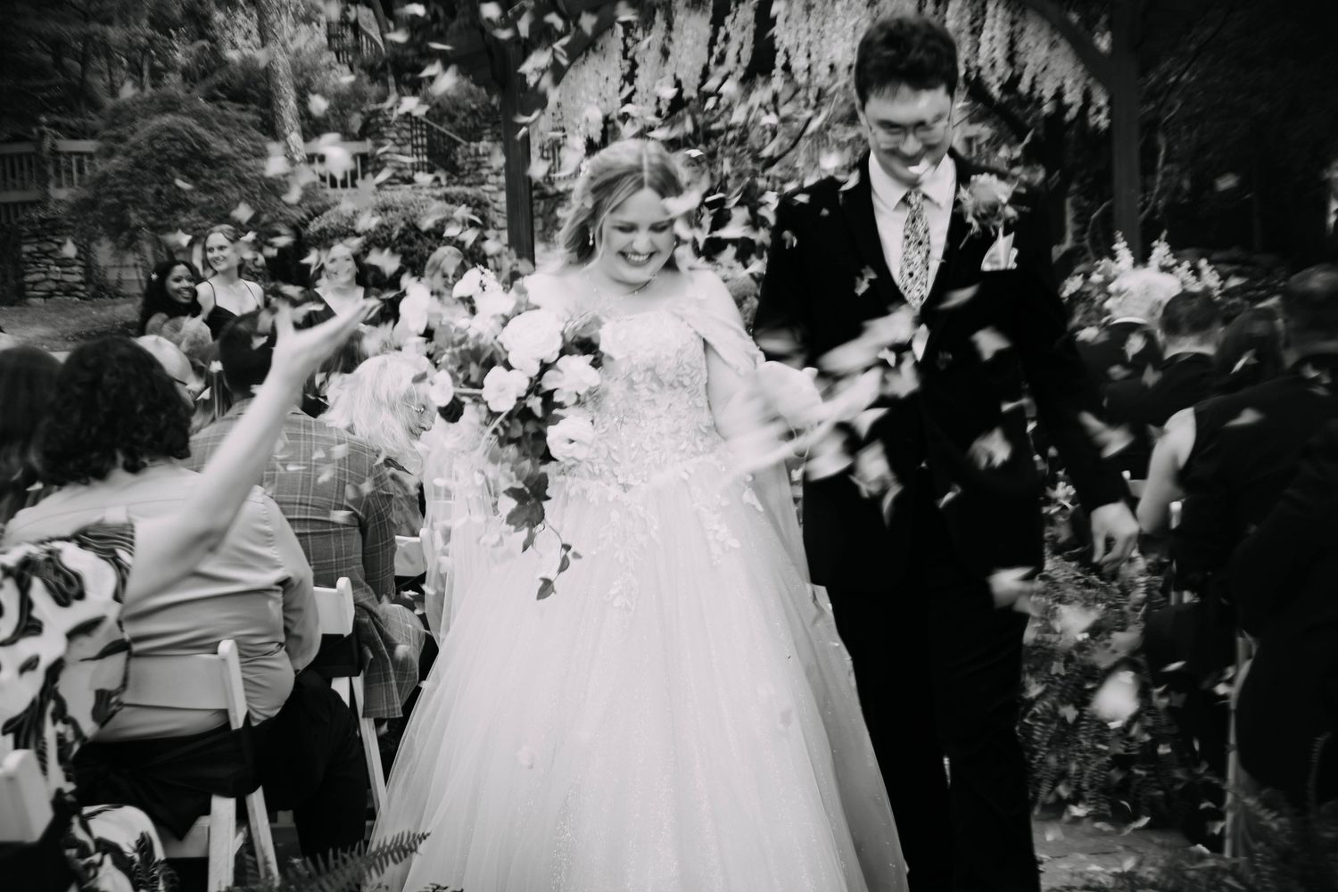 Black and white wedding celebration scene with guests and decor.