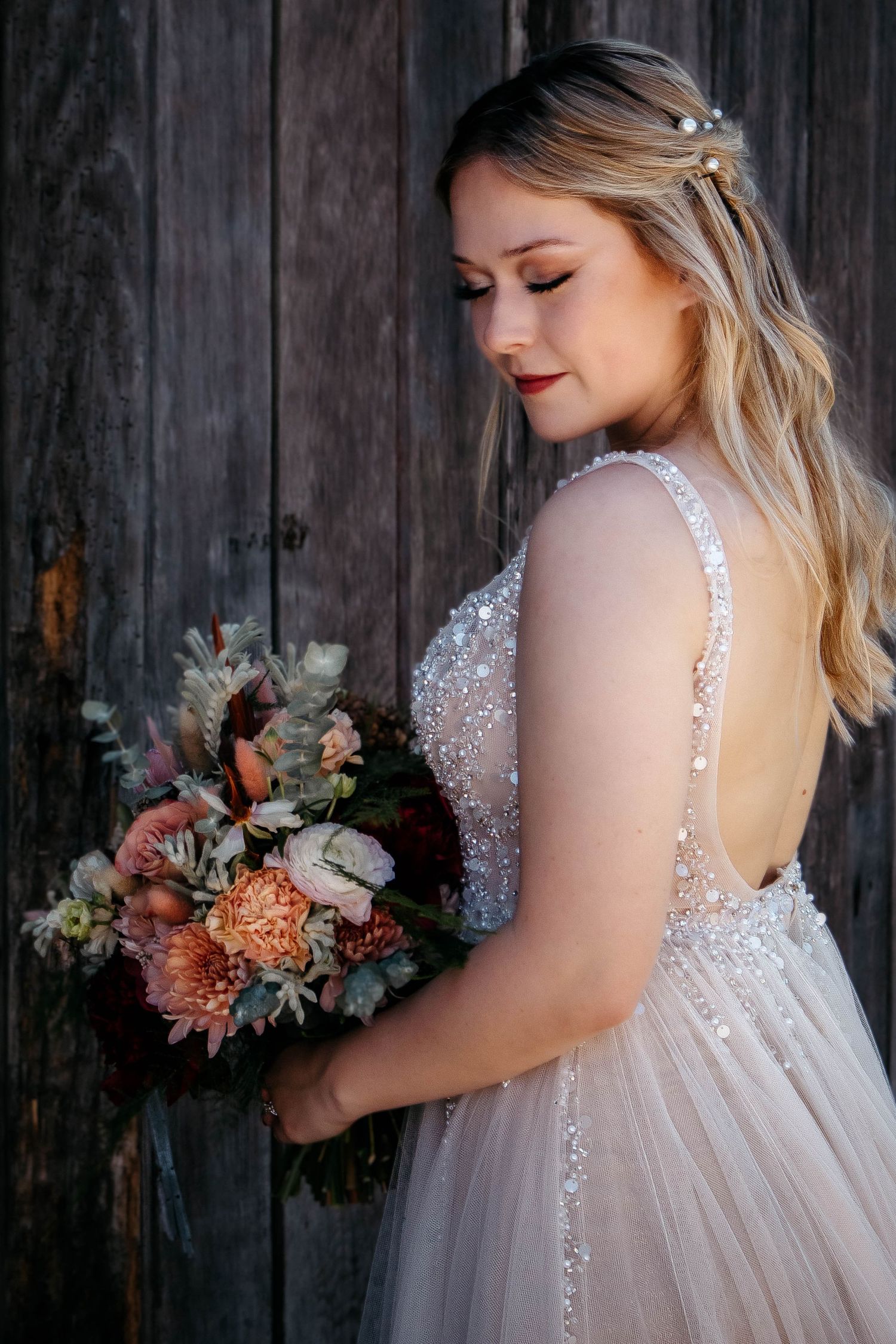 A bridal portrait series showing a romantic wedding dress with lace details and a peach-toned floral bouquet against rustic wood.