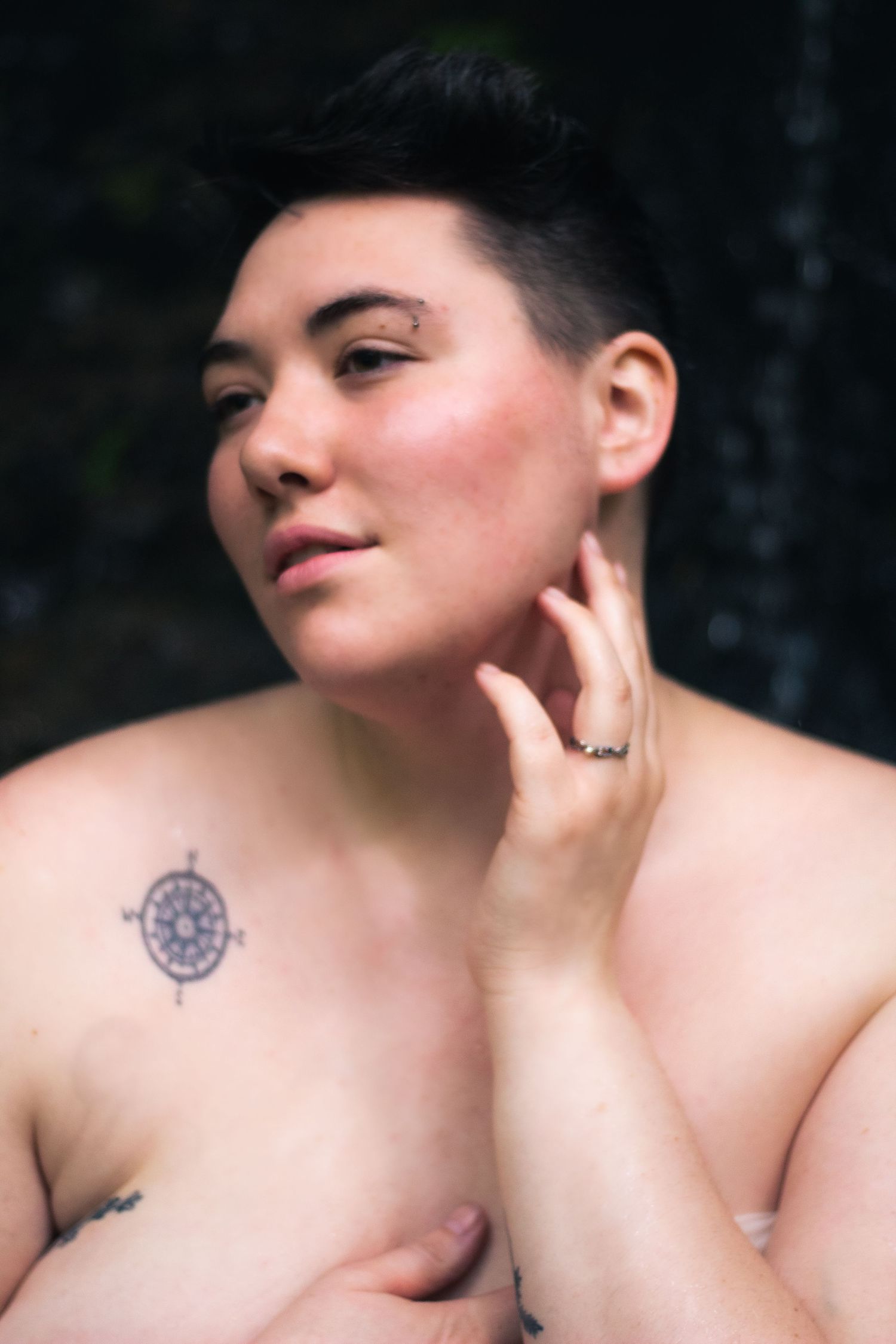 Close-up artistic portrait showing delicate features and tattoo details.
