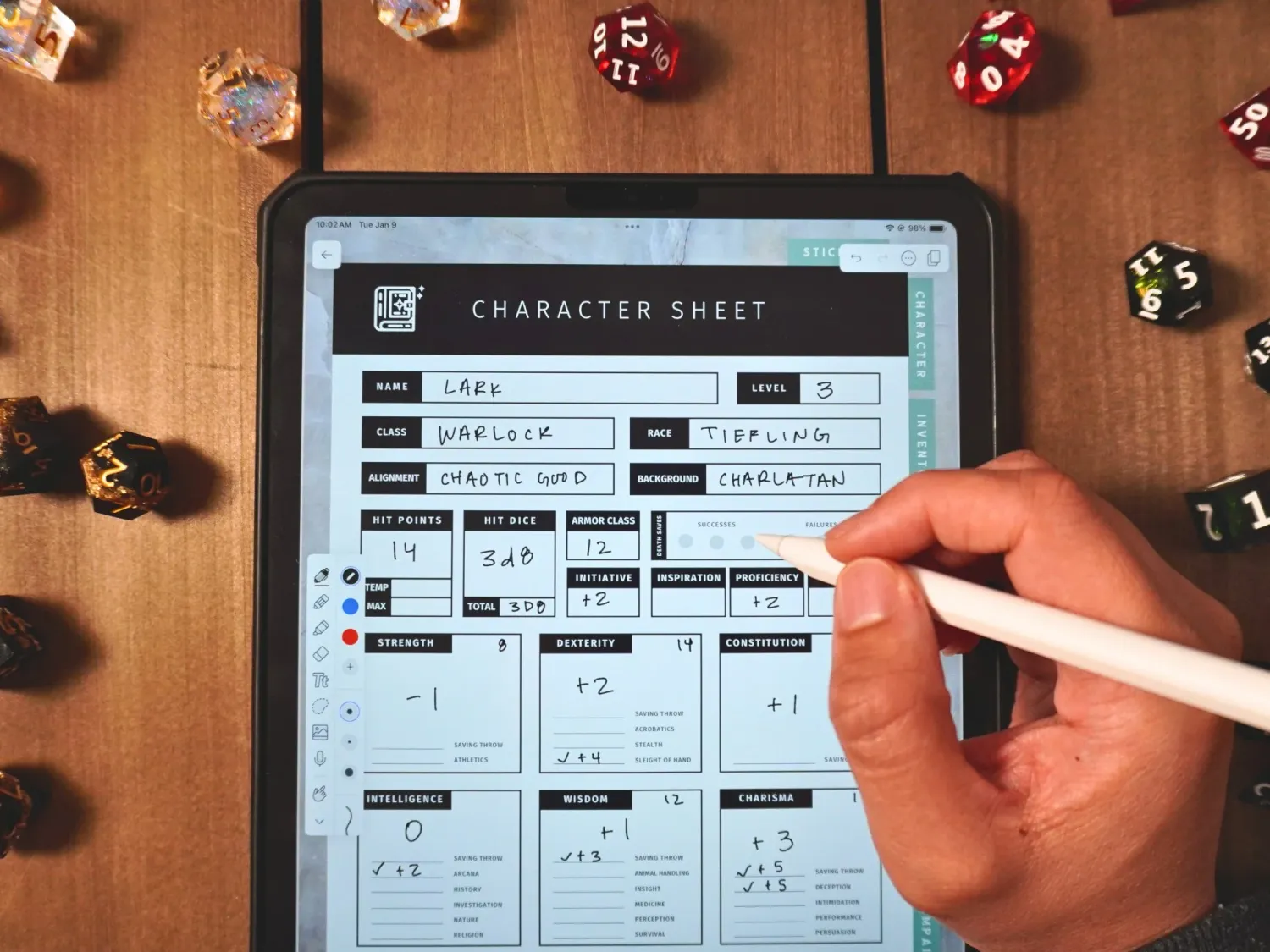 A hand fills out a tabletop roleplaying game character sheet while colorful gaming dice are scattered nearby.