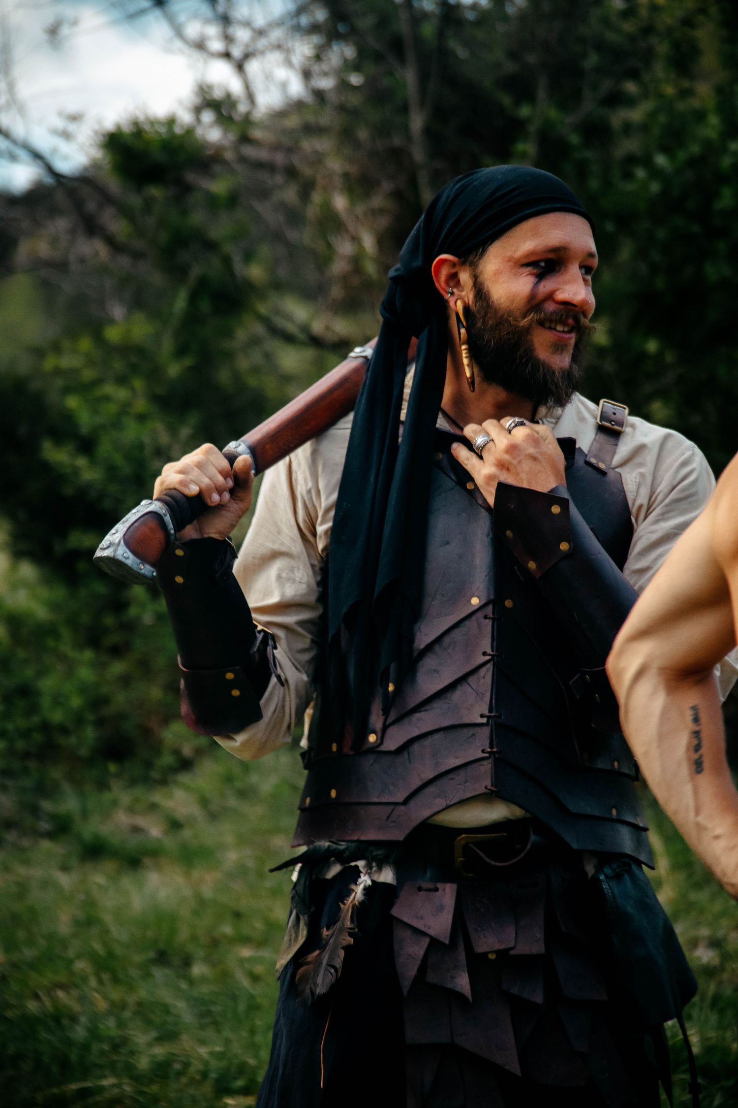 A person in vintage clothing and vest aims an antique pistol in a dramatic outdoor scene.